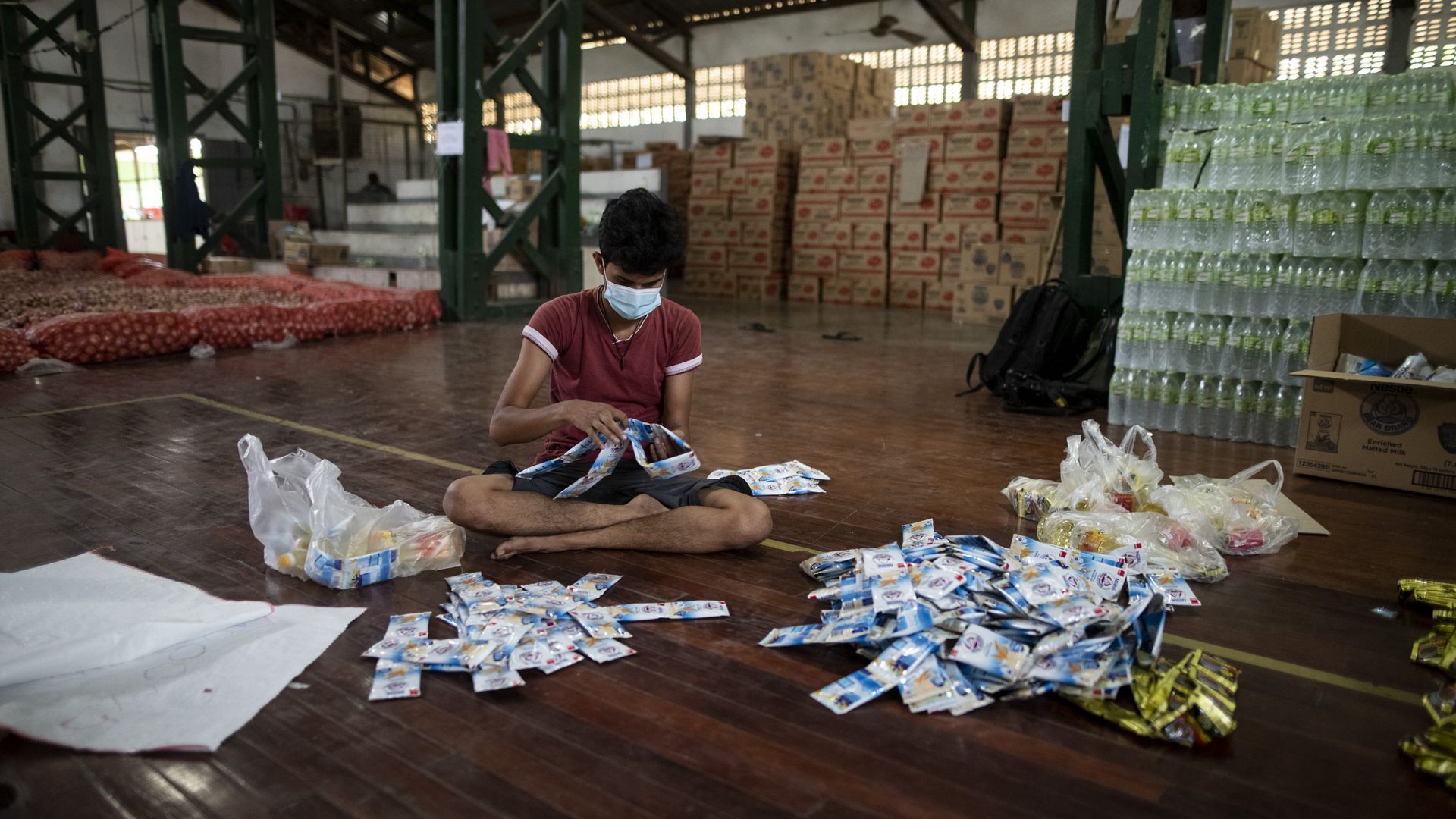 Volunteer in Myanammar rations food for low-income families