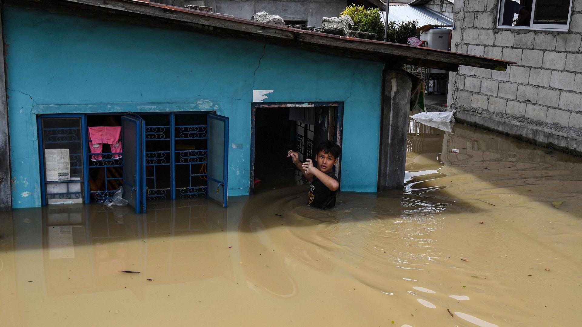 A resident enters his flooded home in the aftermath of Super Typhoon Noru in San Ildefonso, Bulacan province on September 26.