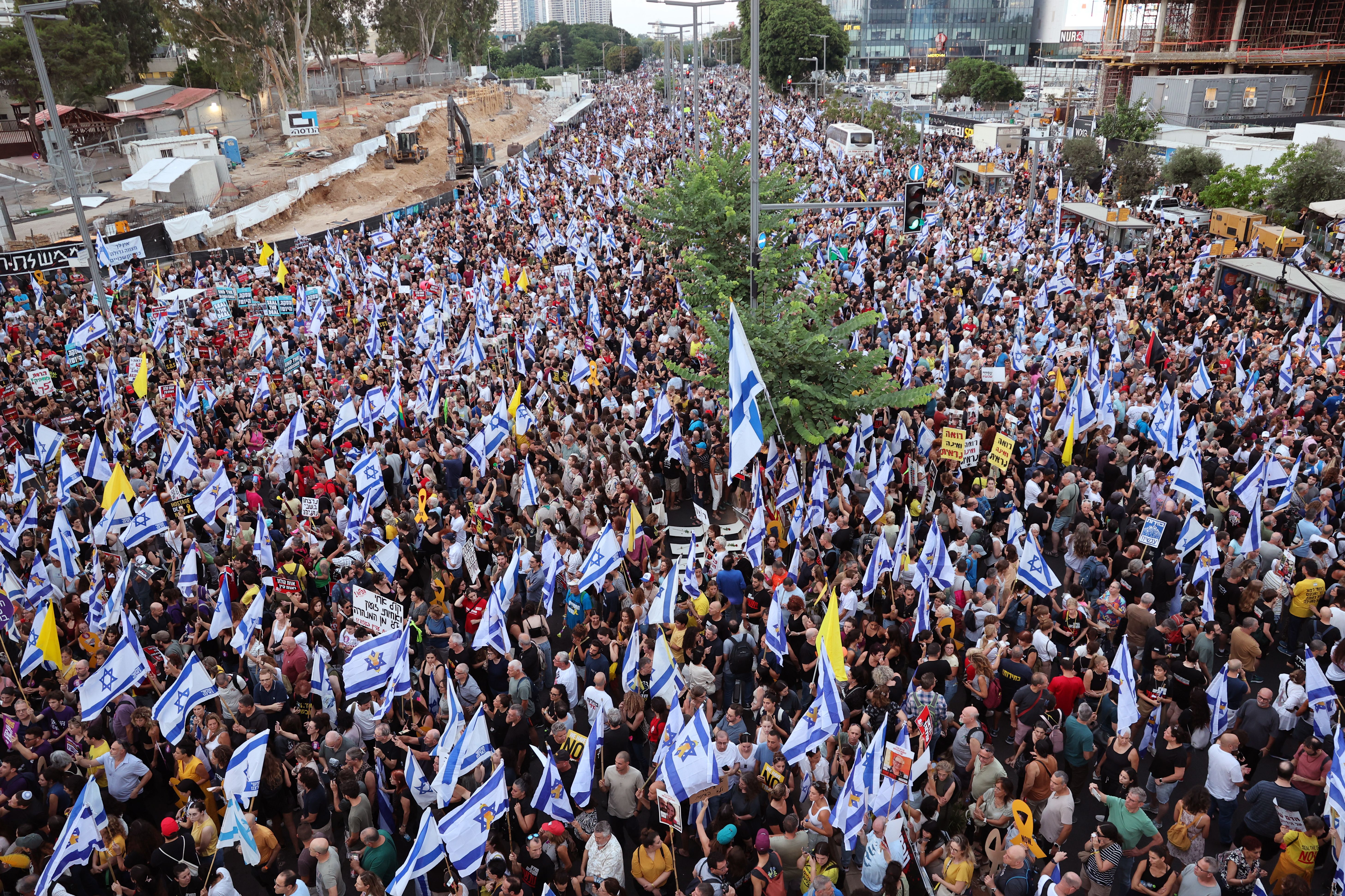 Thousands of protesters lift flags and placards during an anti-government rally calling for the release of Israelis held hostage by Palestinian militants in Gaza since October, in Tel Aviv on September 1, 2024