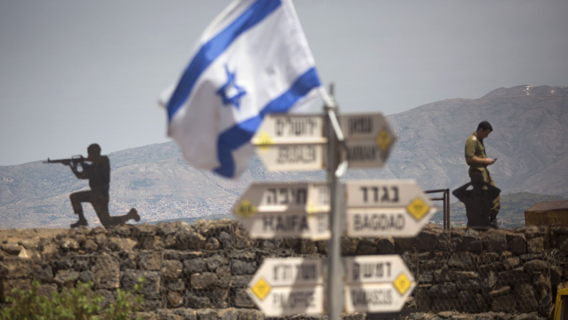  Israeli soldier is seen next to a signs pointing out distance to different cities on Mount Bental next to the Syrian border on May 10, 2018 in the Israeli-annexed Golan Heights. 