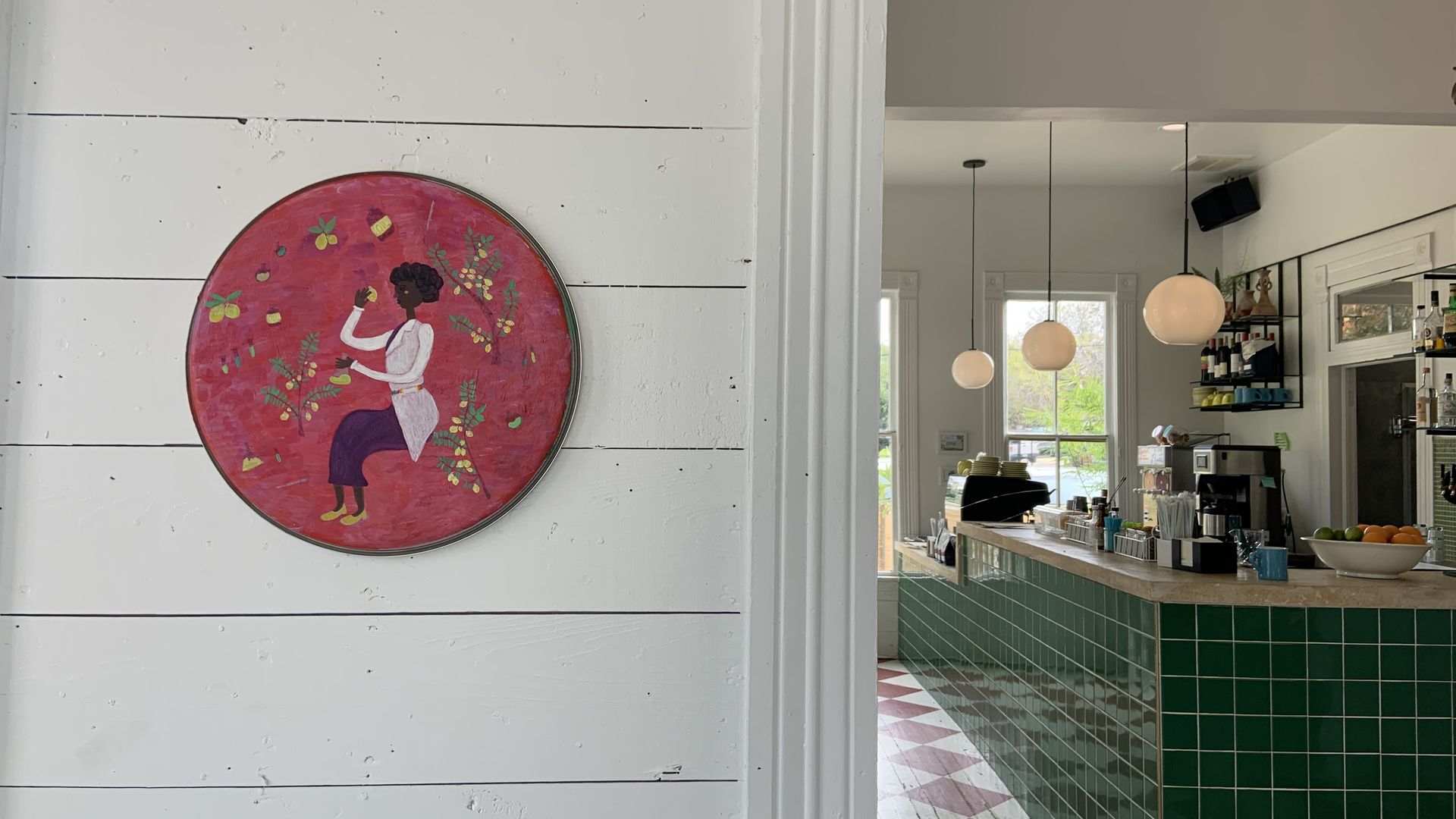 A photo of a painting hanging on a wall with a bar in the background.