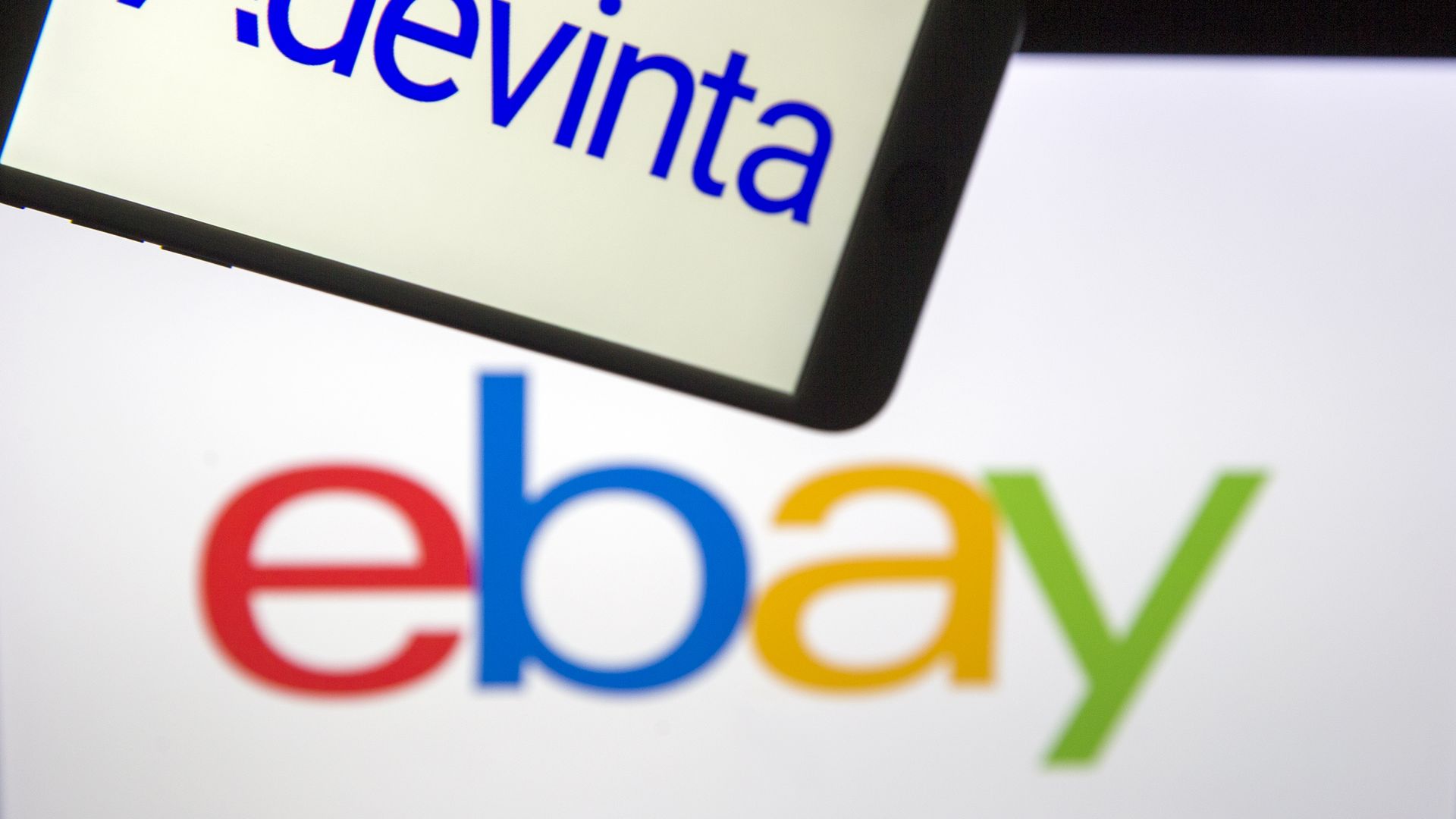 The logo of "Adevinta" is displayed on a smartphone as "ebay" logo is seen at the background on a screen in Ankara, Turkey on July 29, 2020. 