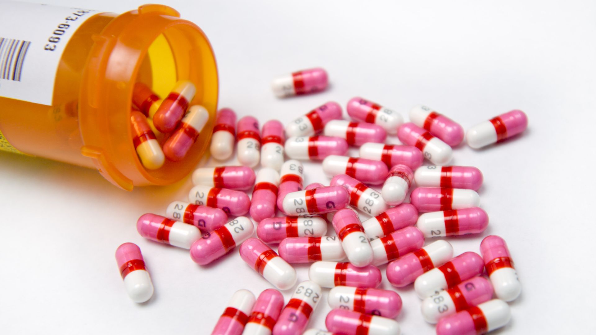 A bottle with prescription pills dumped out.