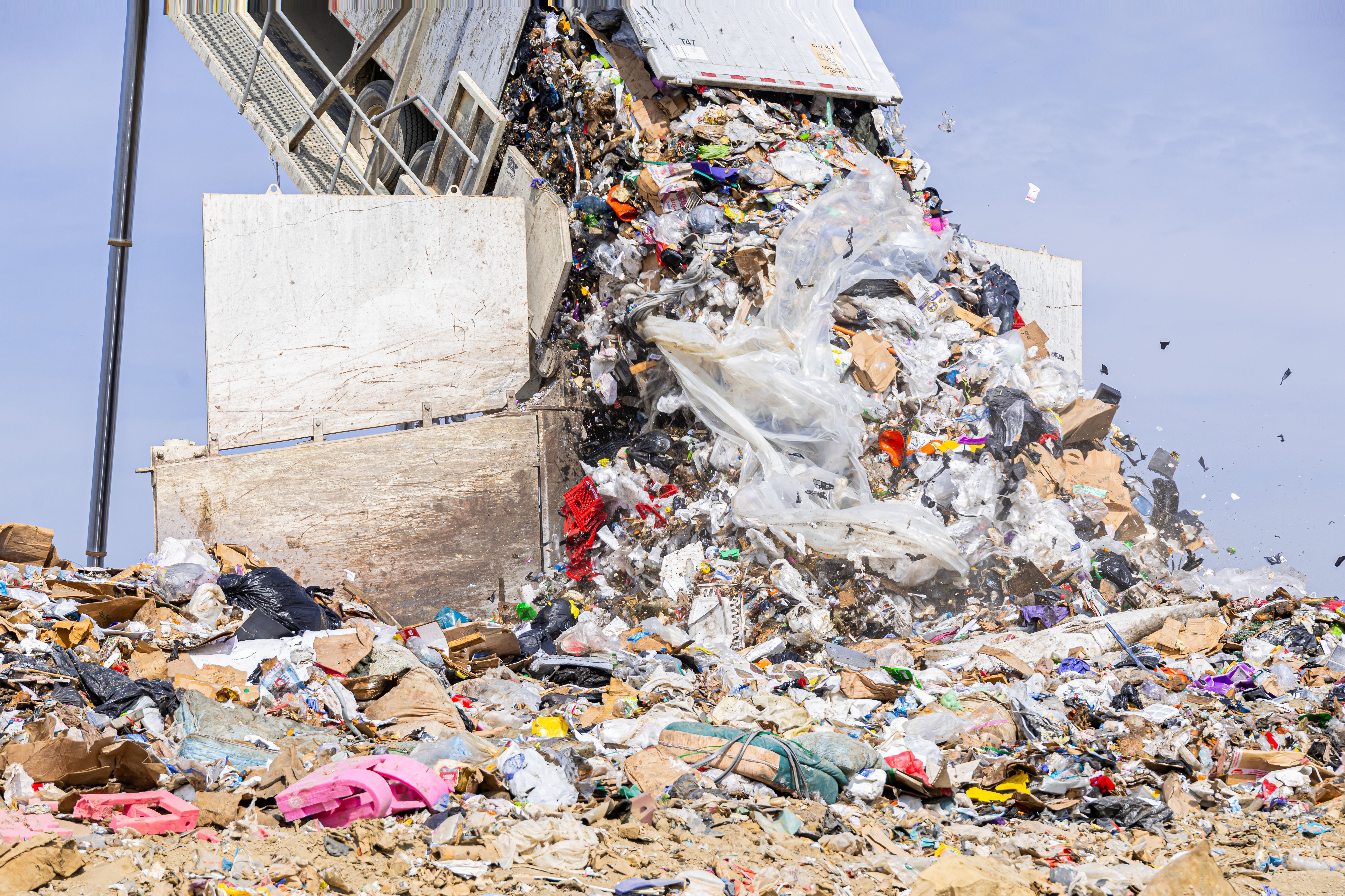 A close-up of trash pouring out of a truck trailer