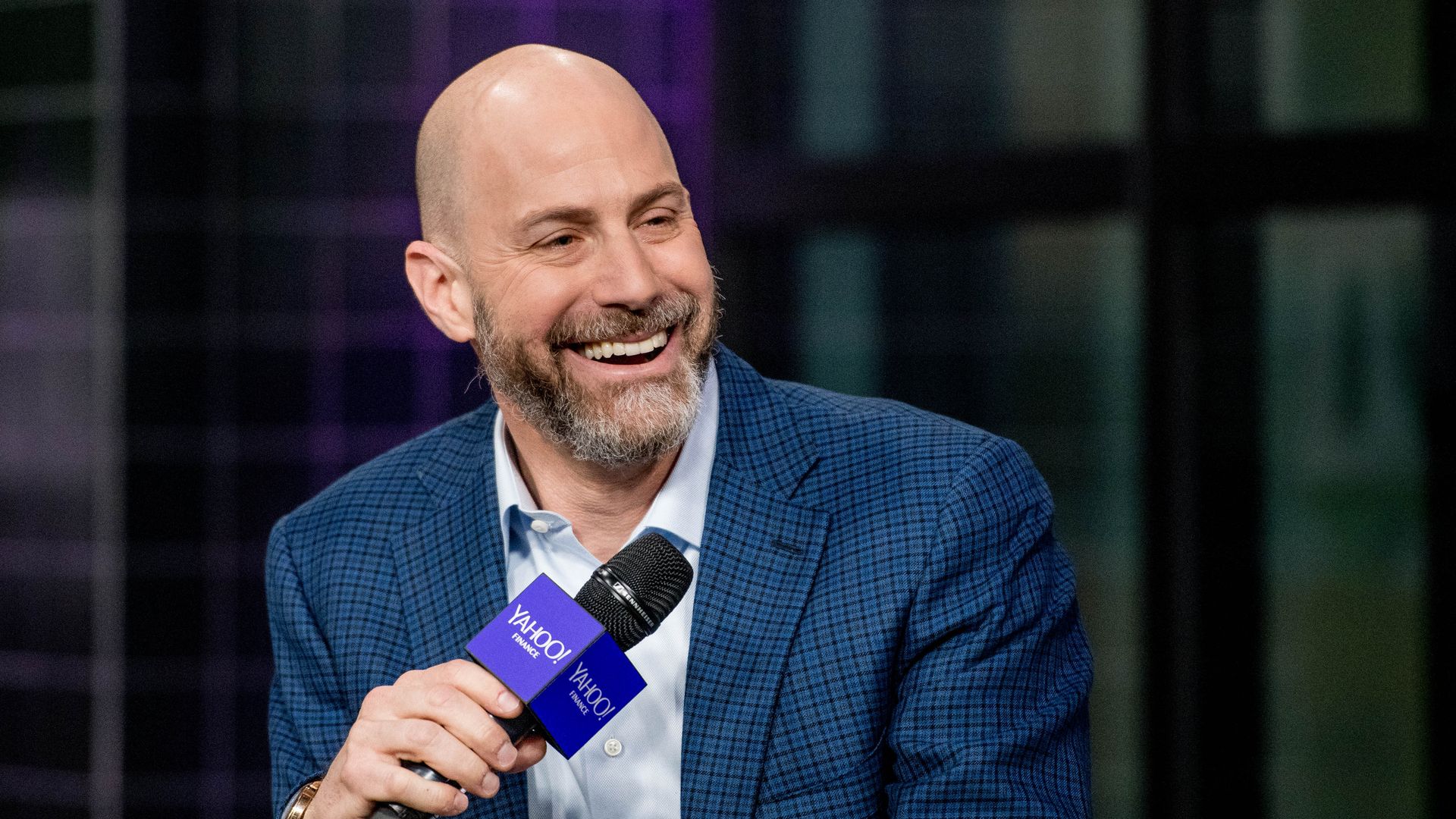 Etsy CEO Josh Silverman during an interview in 2018 smiling and holding a microphone