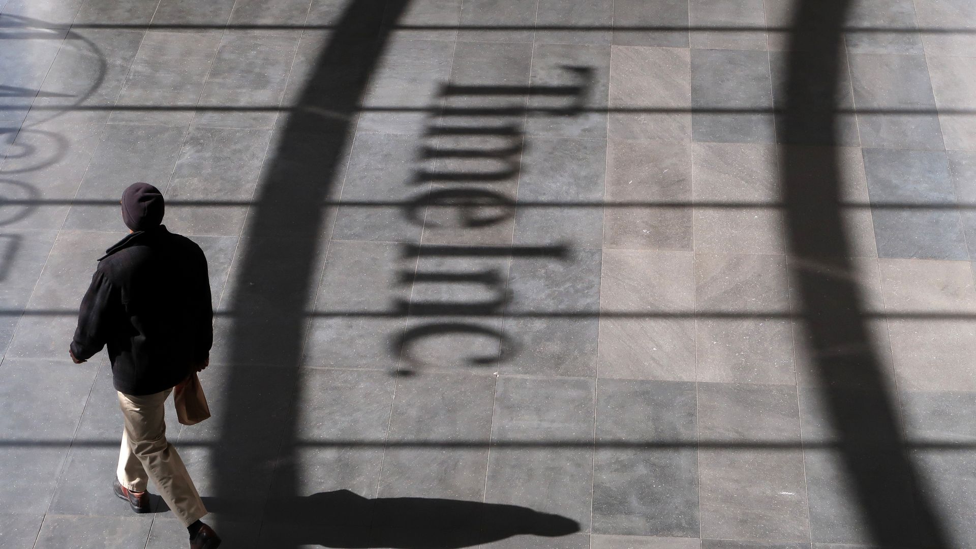 Man walking past shadow of Time Inc. headquarters in lower Manhattan.