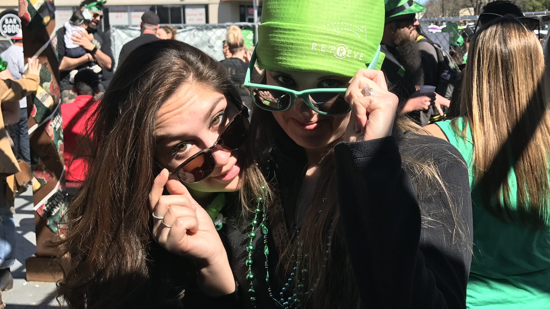 Two beautiful women wearing lots of green at a parade