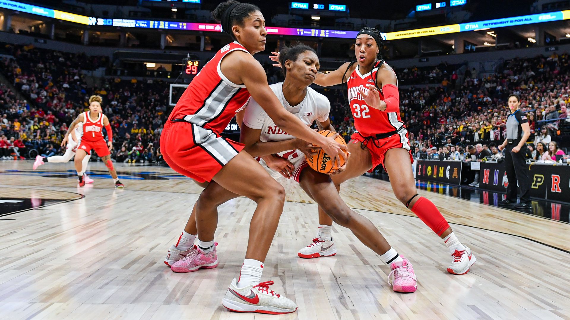 Two OSU women's basketball players swarm an Indiana player with the ball. 