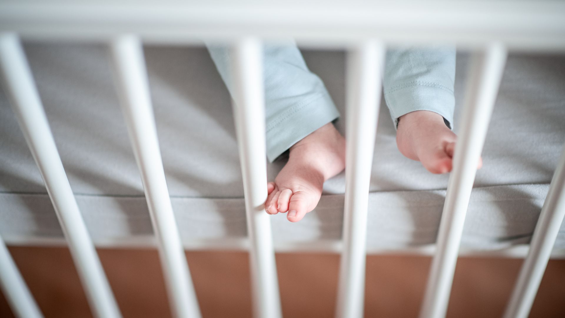 A baby's feet in a crib.