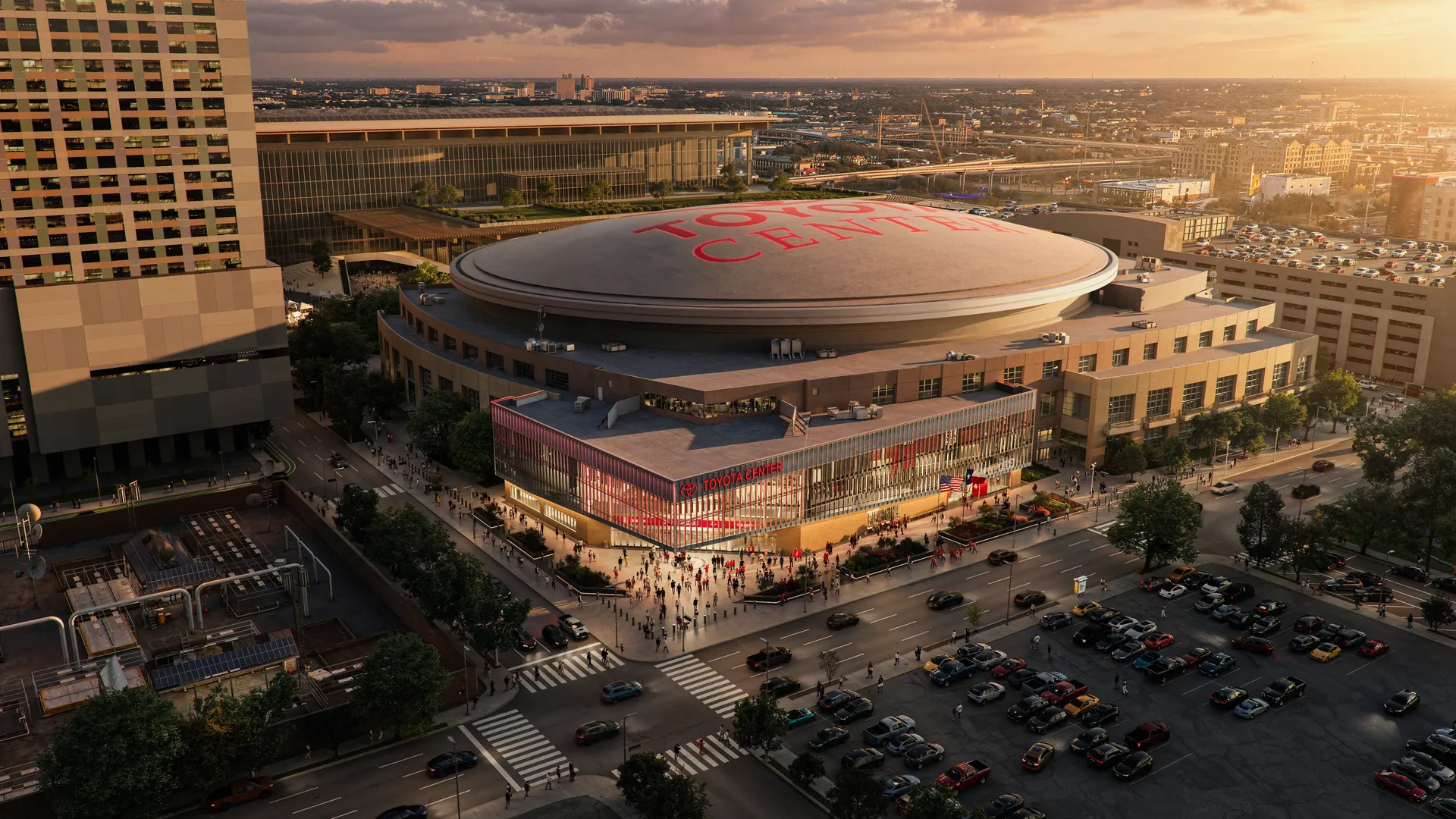 An aerial rendering of the Toyota Center arena at sunset: a circular domed roof with large red letters, a glass-front entrance, a bustling plaza, surrounding streets, and a large parking lot.