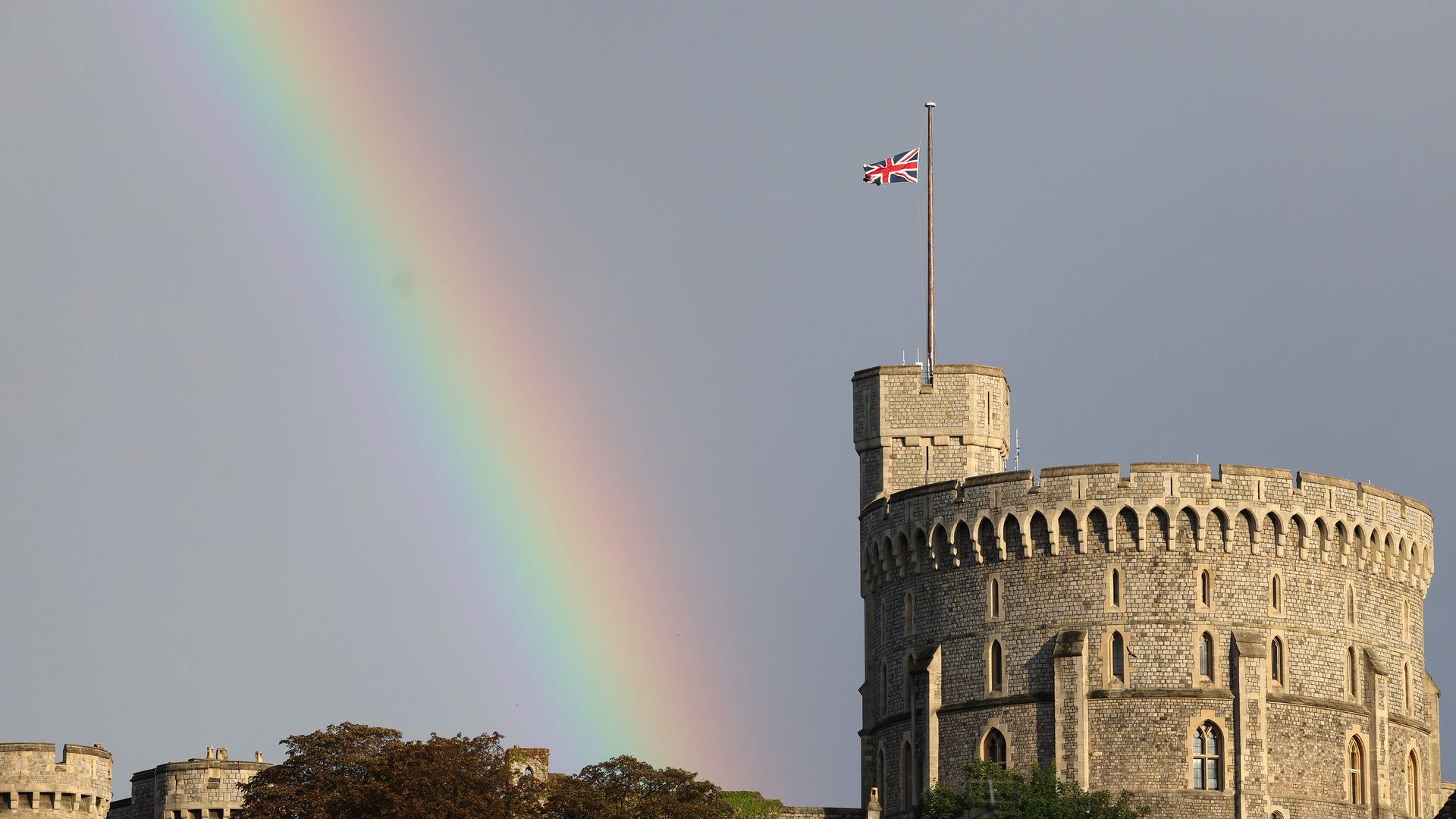  The Union flag is lowered on Windsor Castle as a rainbow covers the sky.
