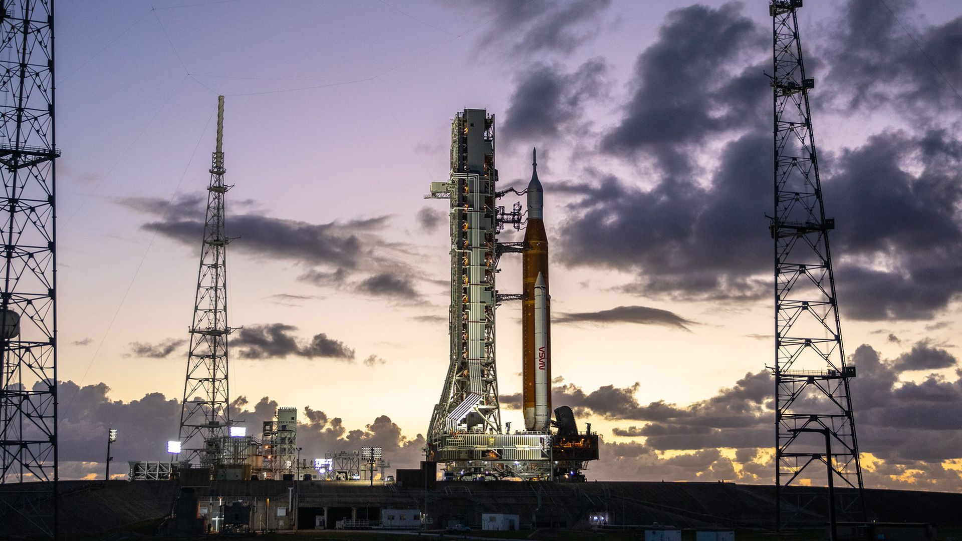 The SLS rocket against a purple and gold sky