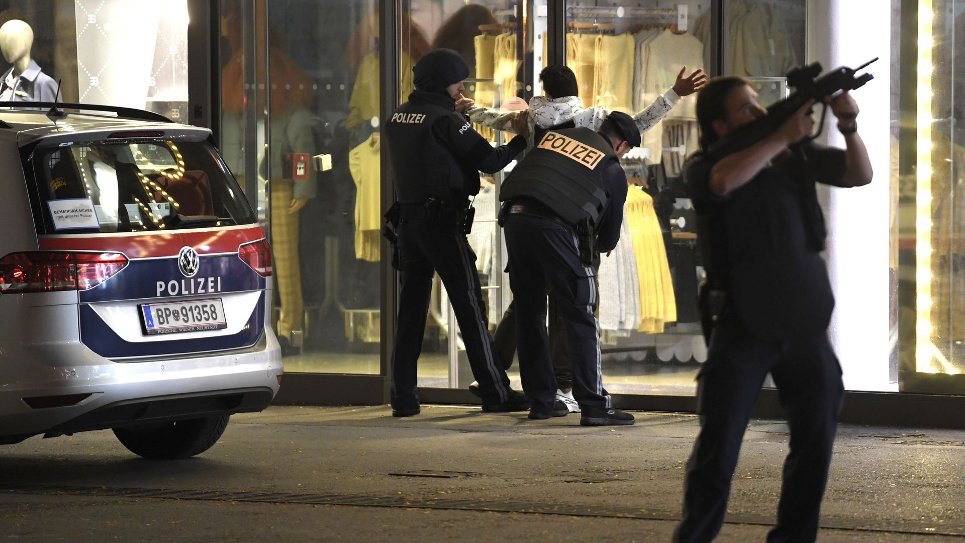 Picture of a man being patted down by police after a shooting in Vienna.