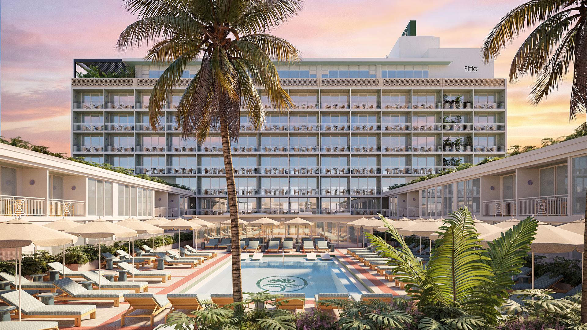 Sunset at a tropical resort: a white multi-story hotel with glass balconies, framed by palm trees. A pool deck with lounge chairs and umbrellas; a fire pit and lush plants in the foreground.