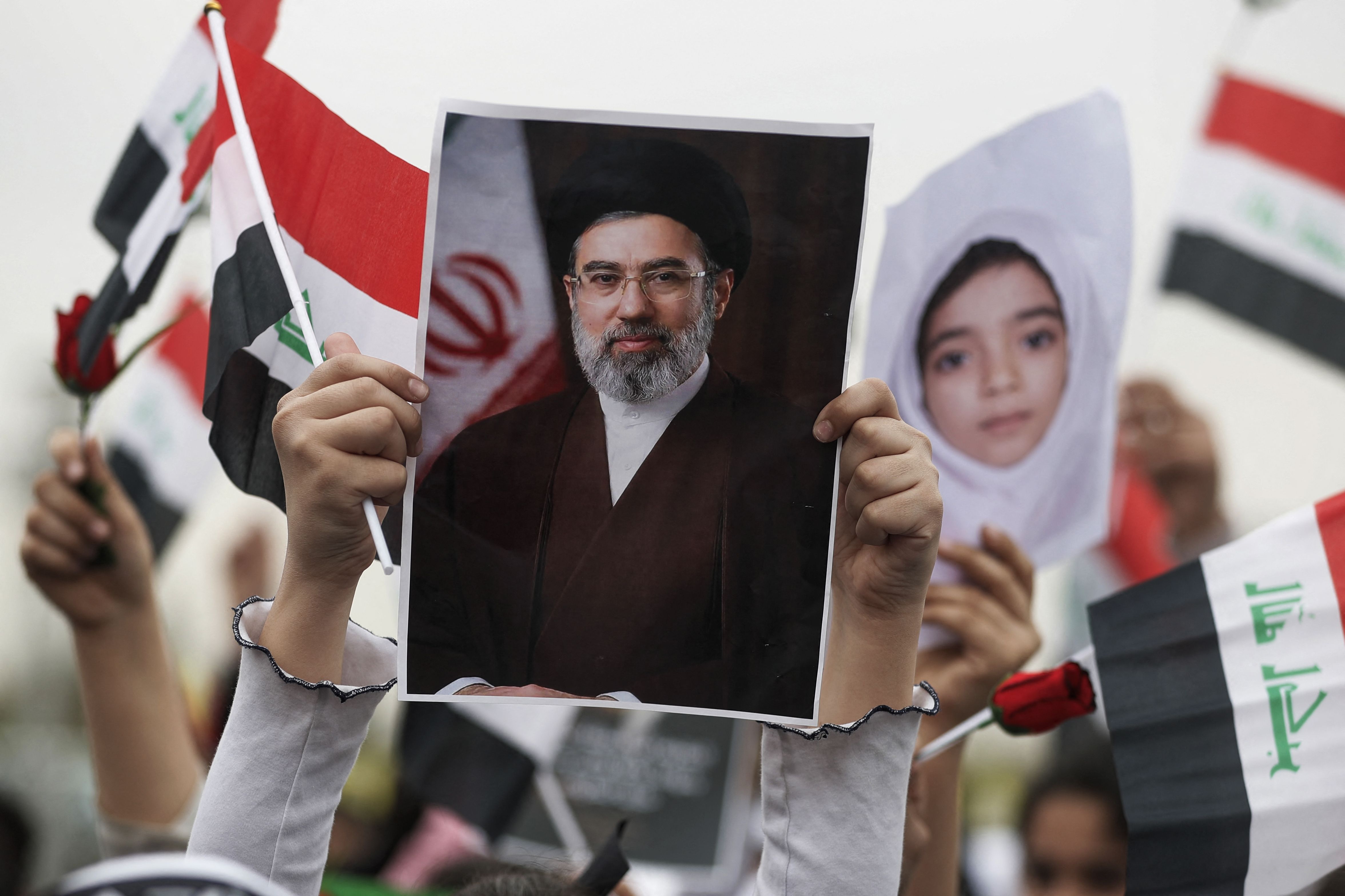 Schoolgirl in Baghdad holding a poster of Mojtaba Khamenei during an anti-U.S. and Israel protest.