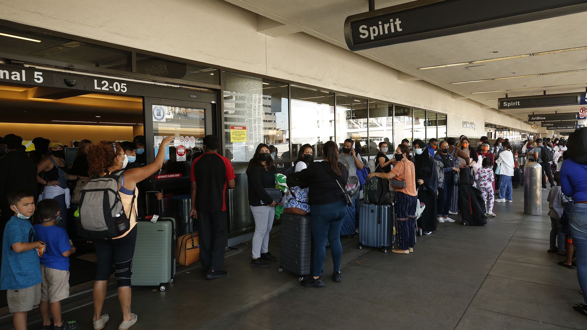 Passengers outside LAX terminal as Spirit Airlines canceled hundreds of flights earlier this week.