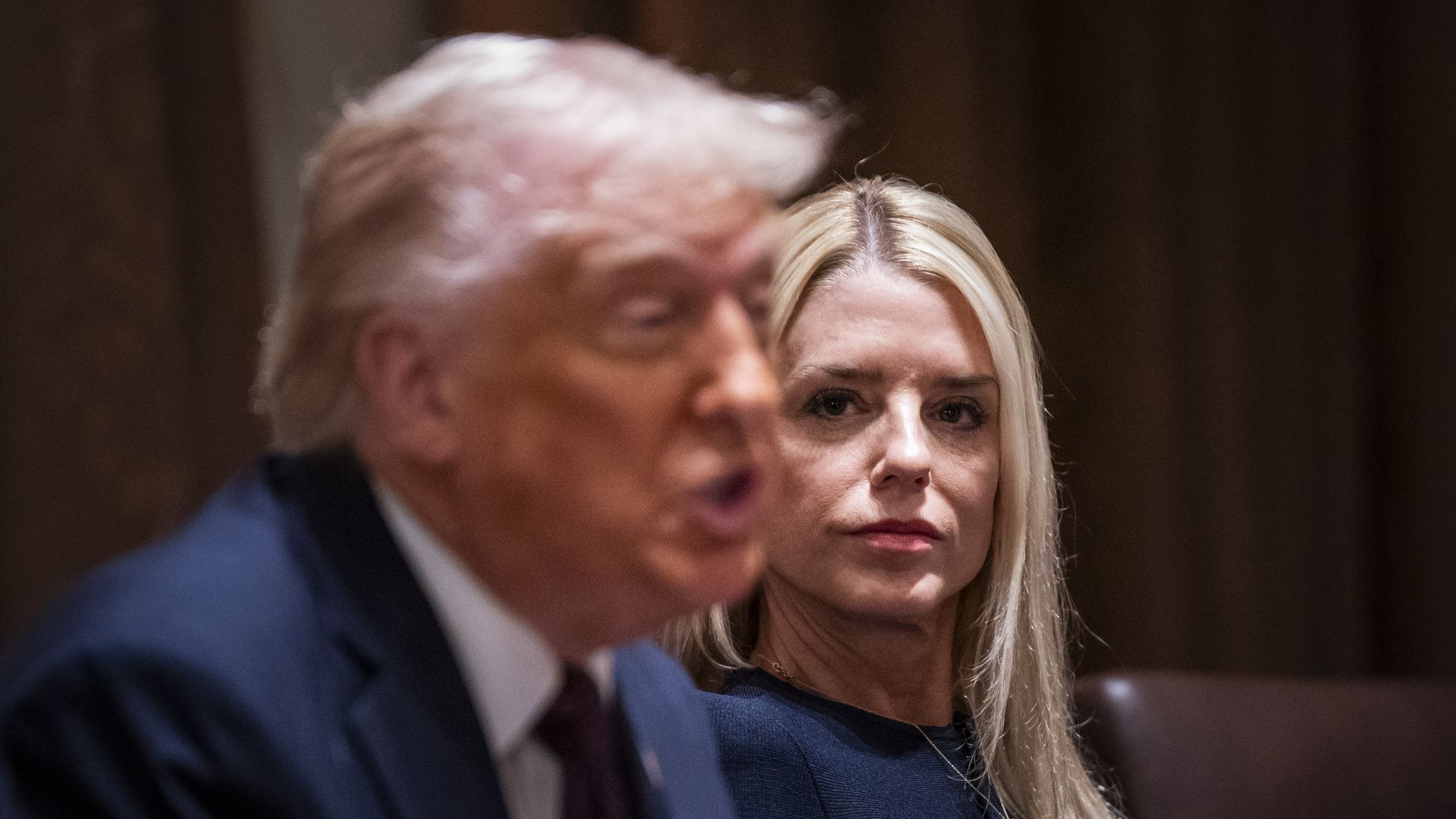 Pam Bondi watches as President Trump speaks during a cabinet meeting.
