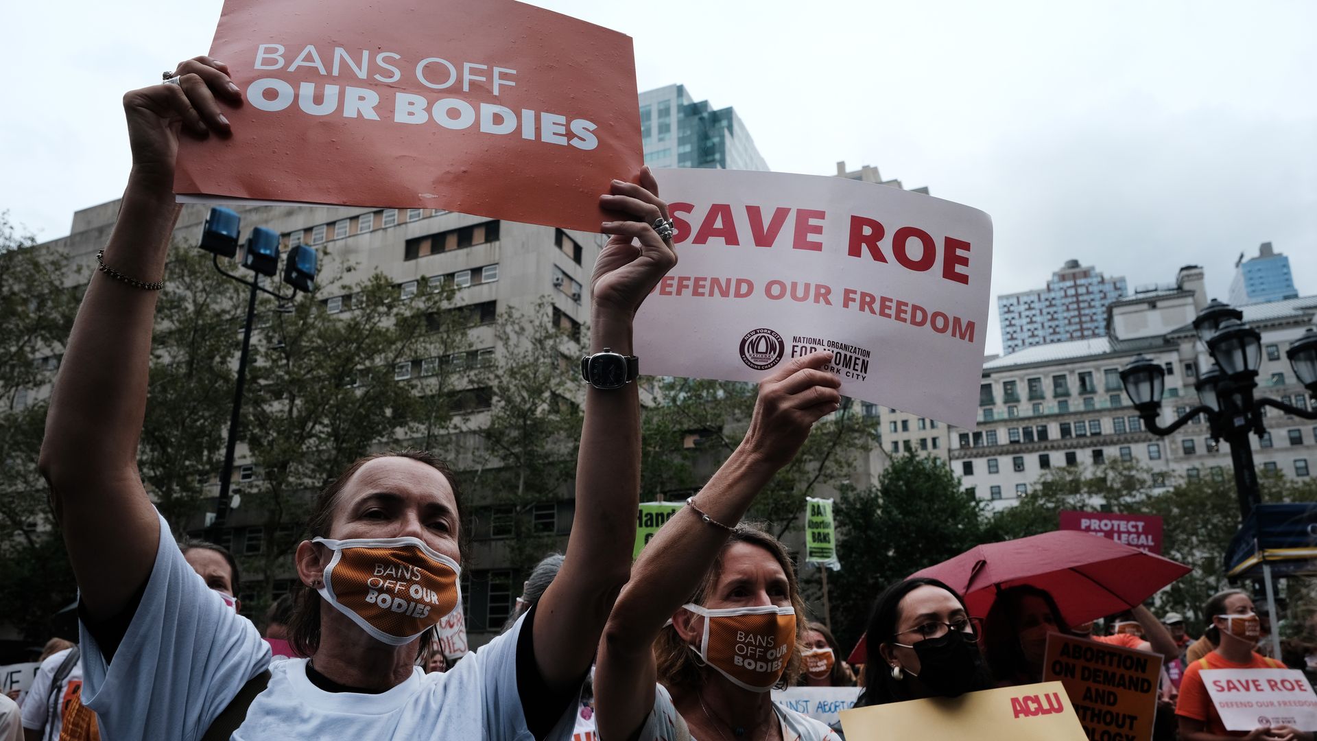 Photo of protesters holding signs that say "Save Roe" and "Bans off our bodies" 