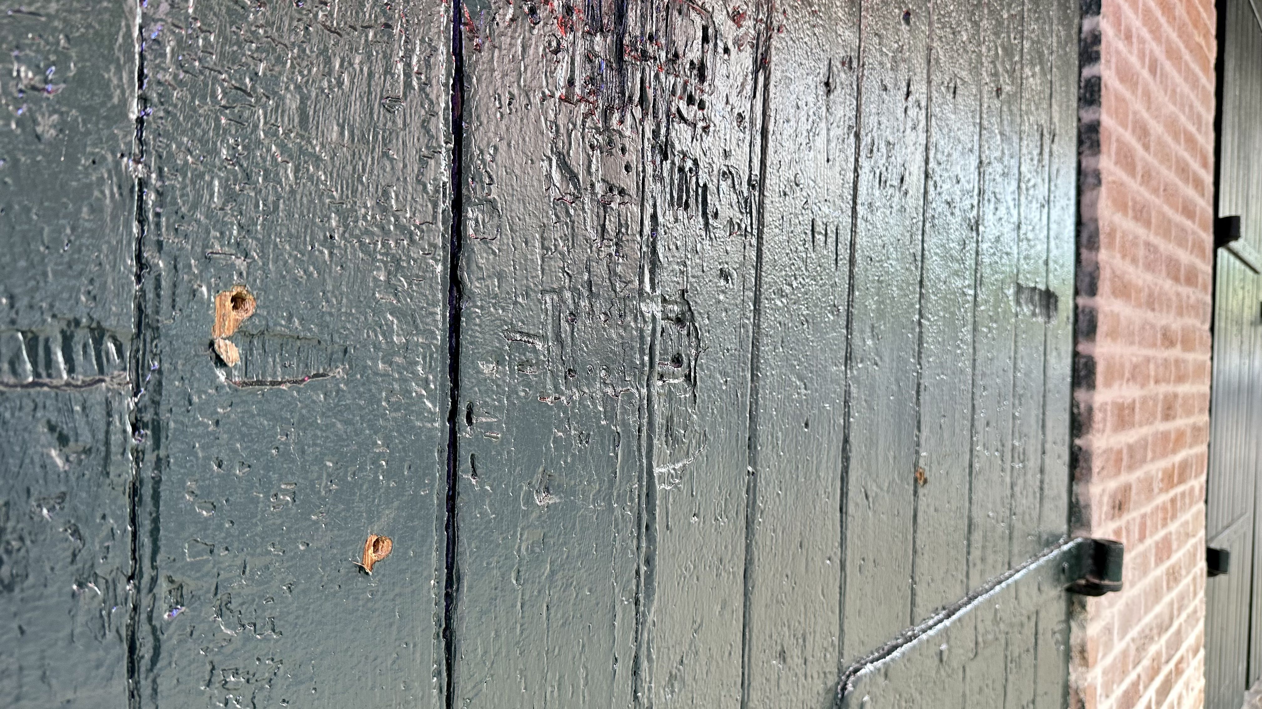 Photo shows three bullet holes in the green, wooden doors of Republic NOLA.