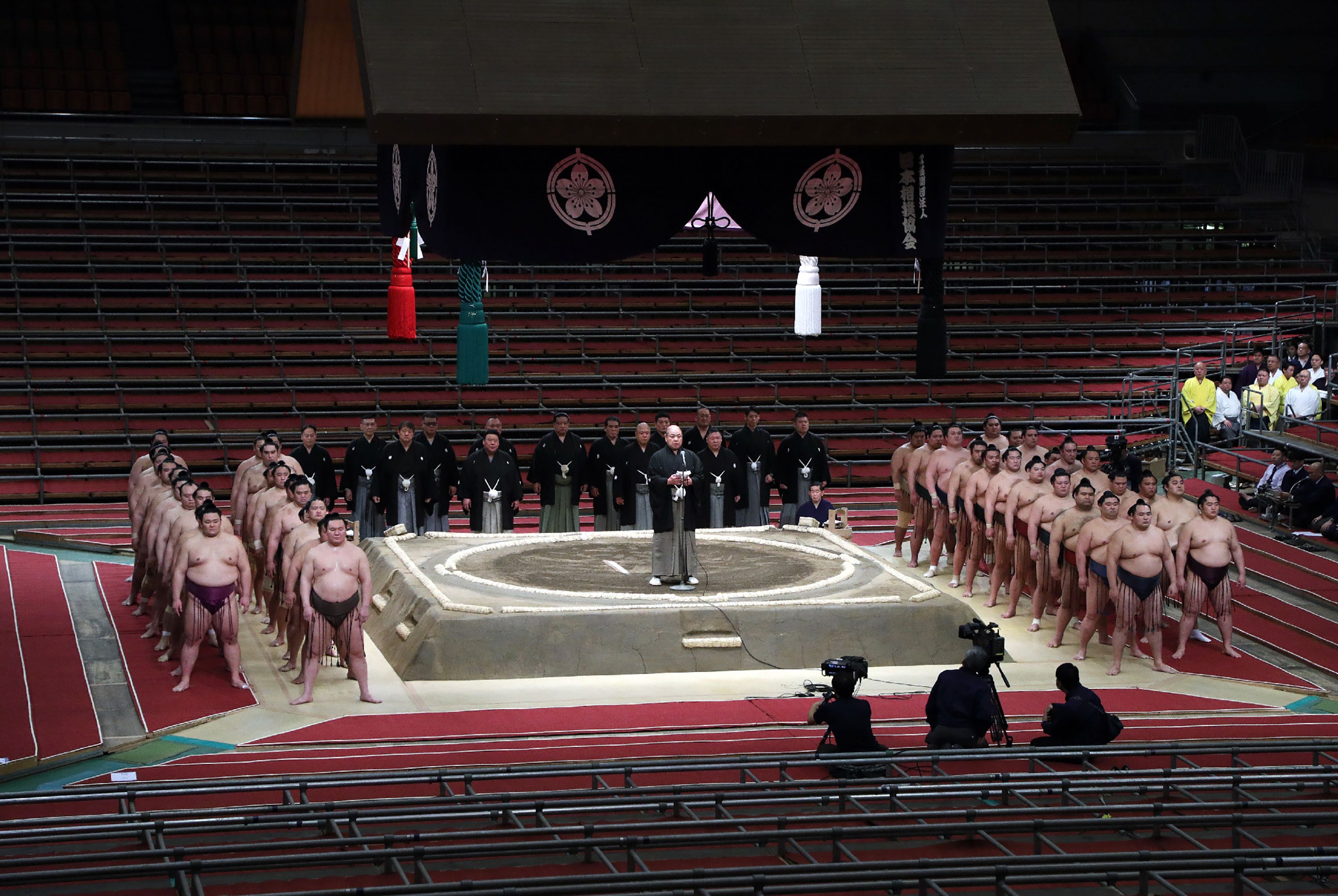 Sumo wrestlers in front of empty stands