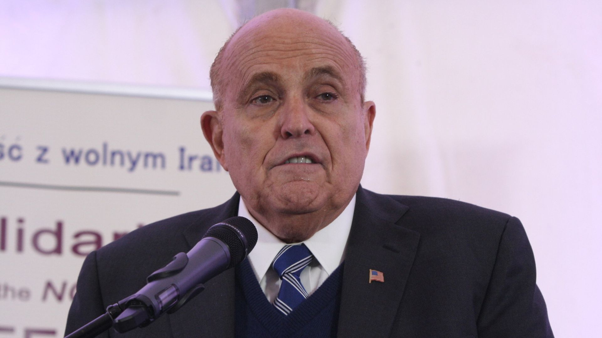 In this image, Rudy speaks into a microphone.