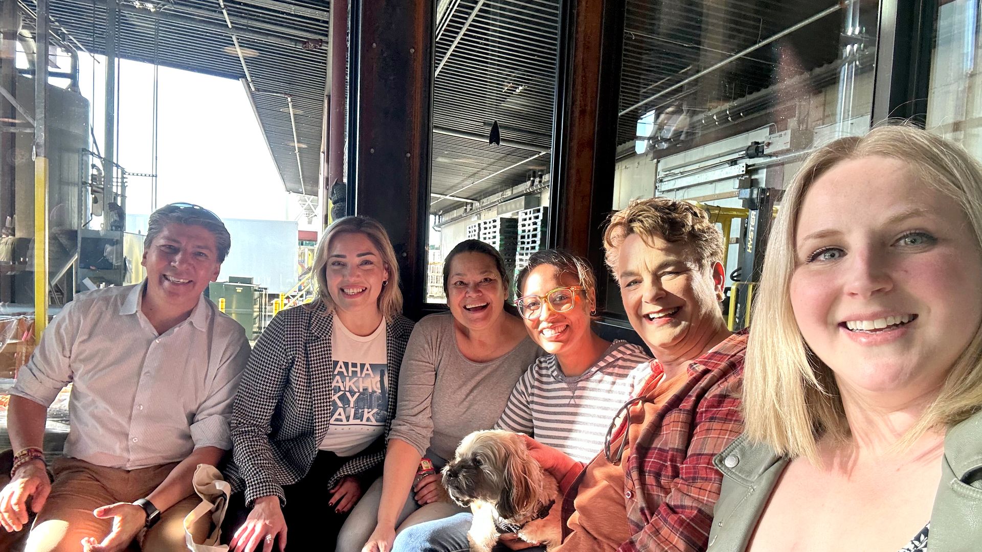 A group of people smiling for a selfie-style shot in a Seattle brewery. 