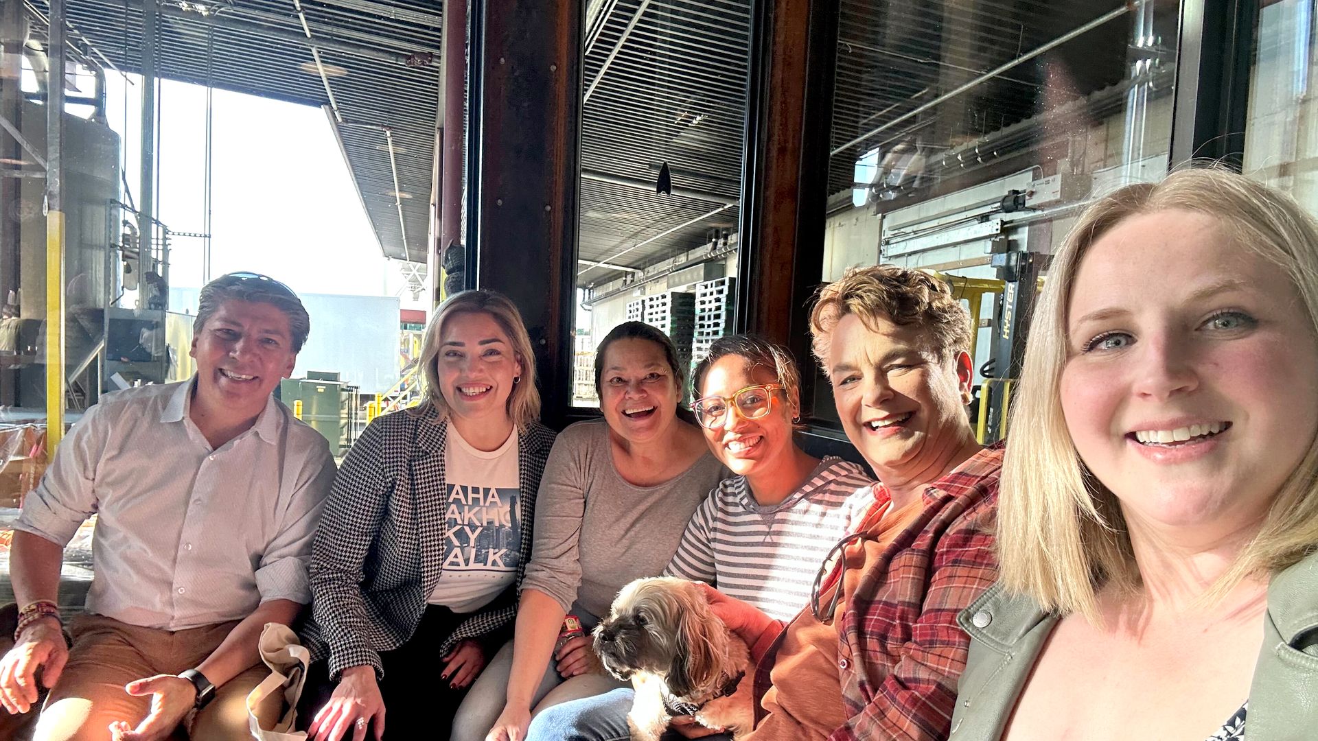 A group of people smiling for a selfie-style shot in a Seattle brewery. 