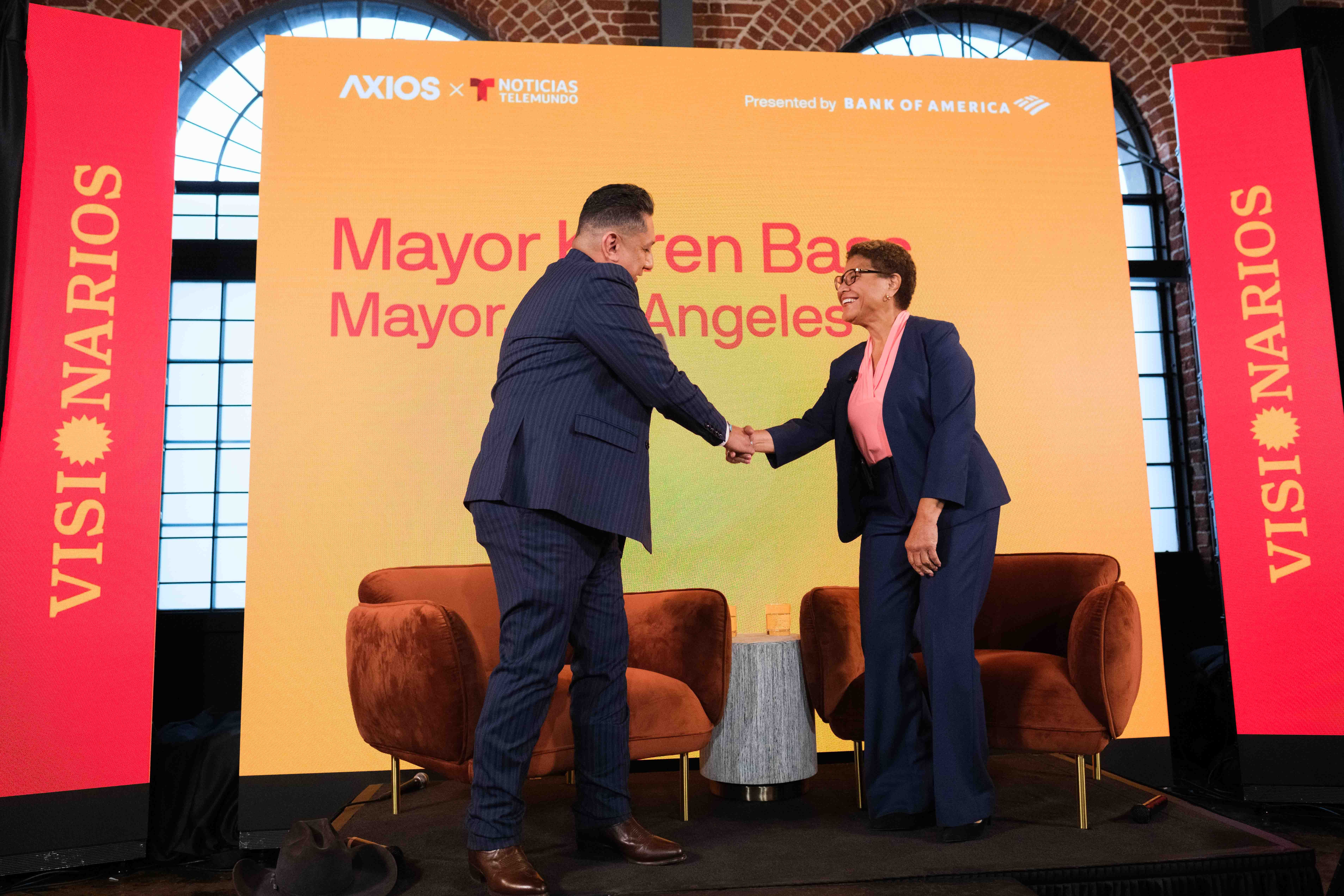 Axios' Russell Contreras shakes hands with LA Mayor Karen Bass on the Visionarios stage.