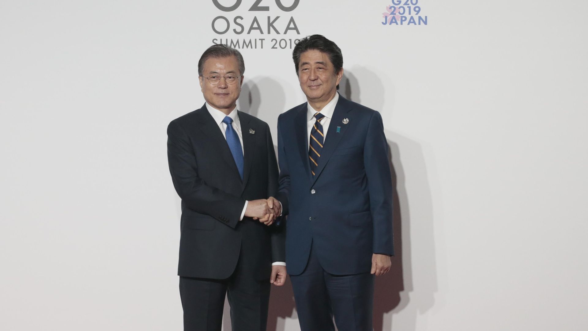 South Korea President Moon Jae-in is welcomed by Japanese Prime Minister Shinzo Abe on the first day of the G20 summit in Osaka, Japan