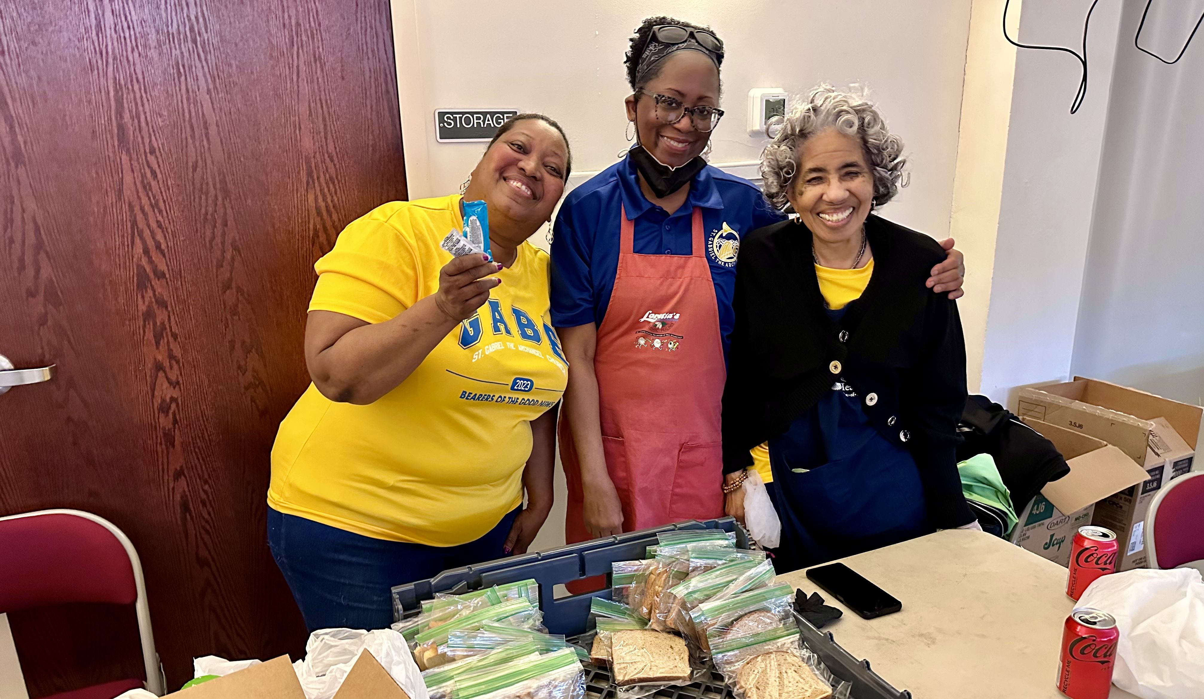 Photo shows three women smiling and workin the bread table at St. Gabriel's fish fry.