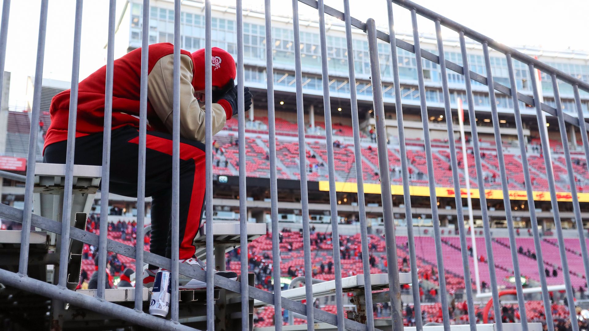 A Buckeyes fan sits disappointed in the OSU football stadium. 