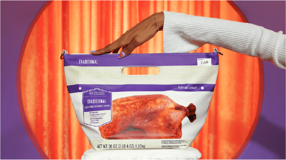 A rotisserie chicken purse labeled "TRADITIONAL" is displayed upright against a bright orange curtain backdrop.