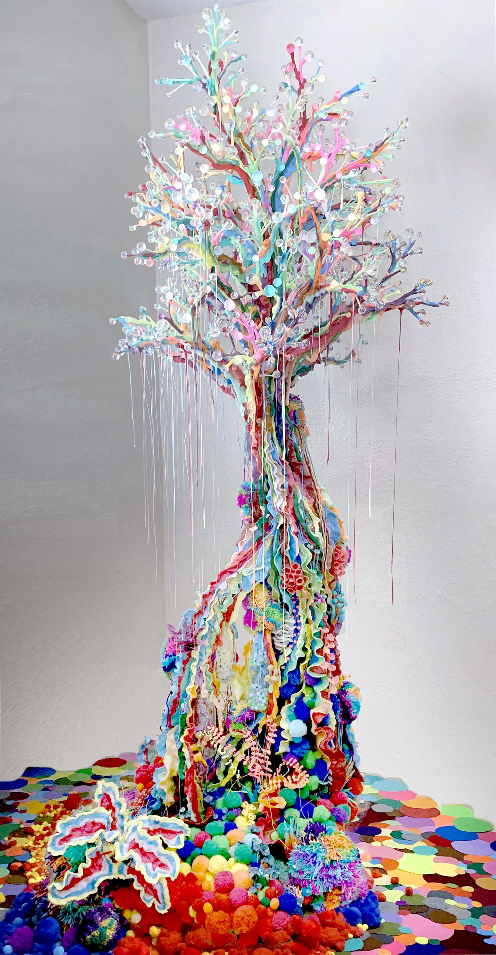 a rainbow tree made of pom poms as the base, resin twisted into a trunk, melted plastic dripping like moss and glass balls as fruit