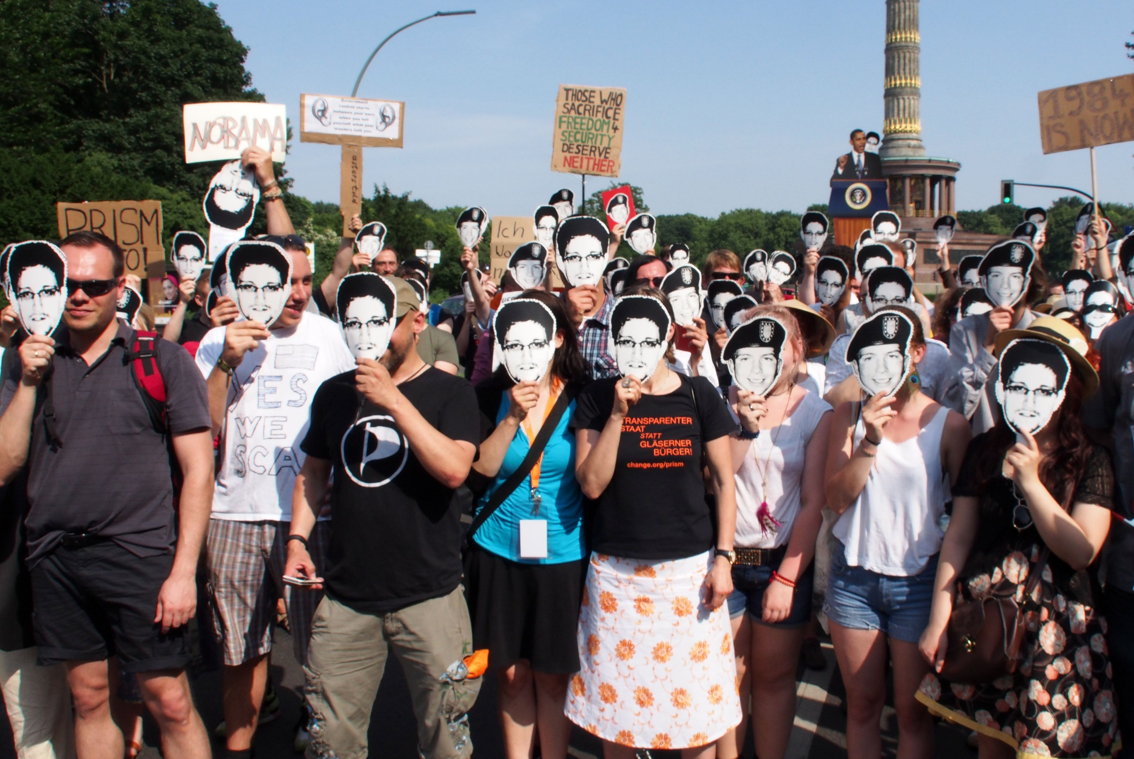  Demonstrators at a protest against the PRISM electronic surveillance program wear masks depicting Bradley Manning and Edward Snowden, on June 19, 2013 in Berlin