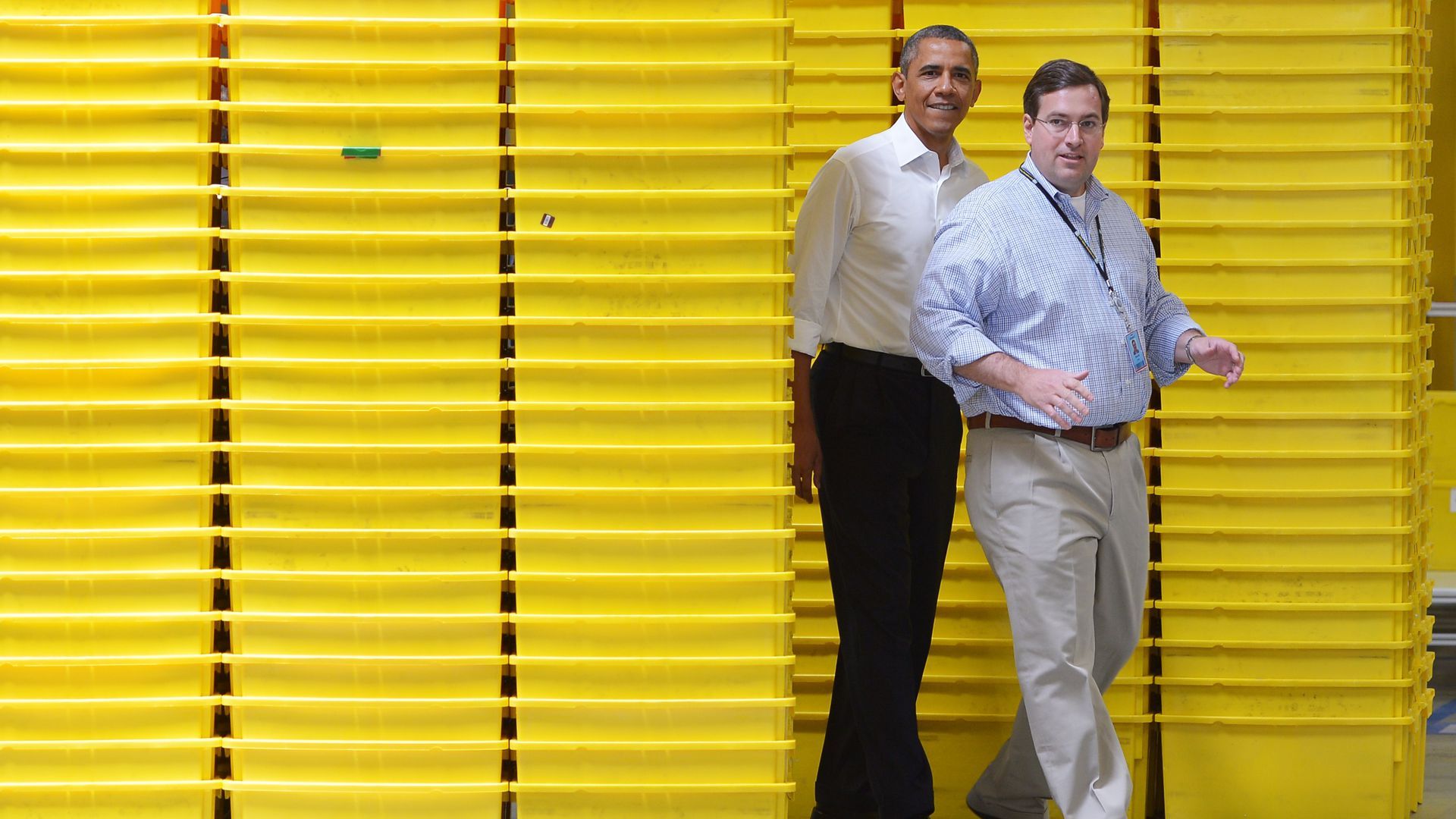 Then-President Barack Obama with Amazon executive Dave Clark amid yellow bins