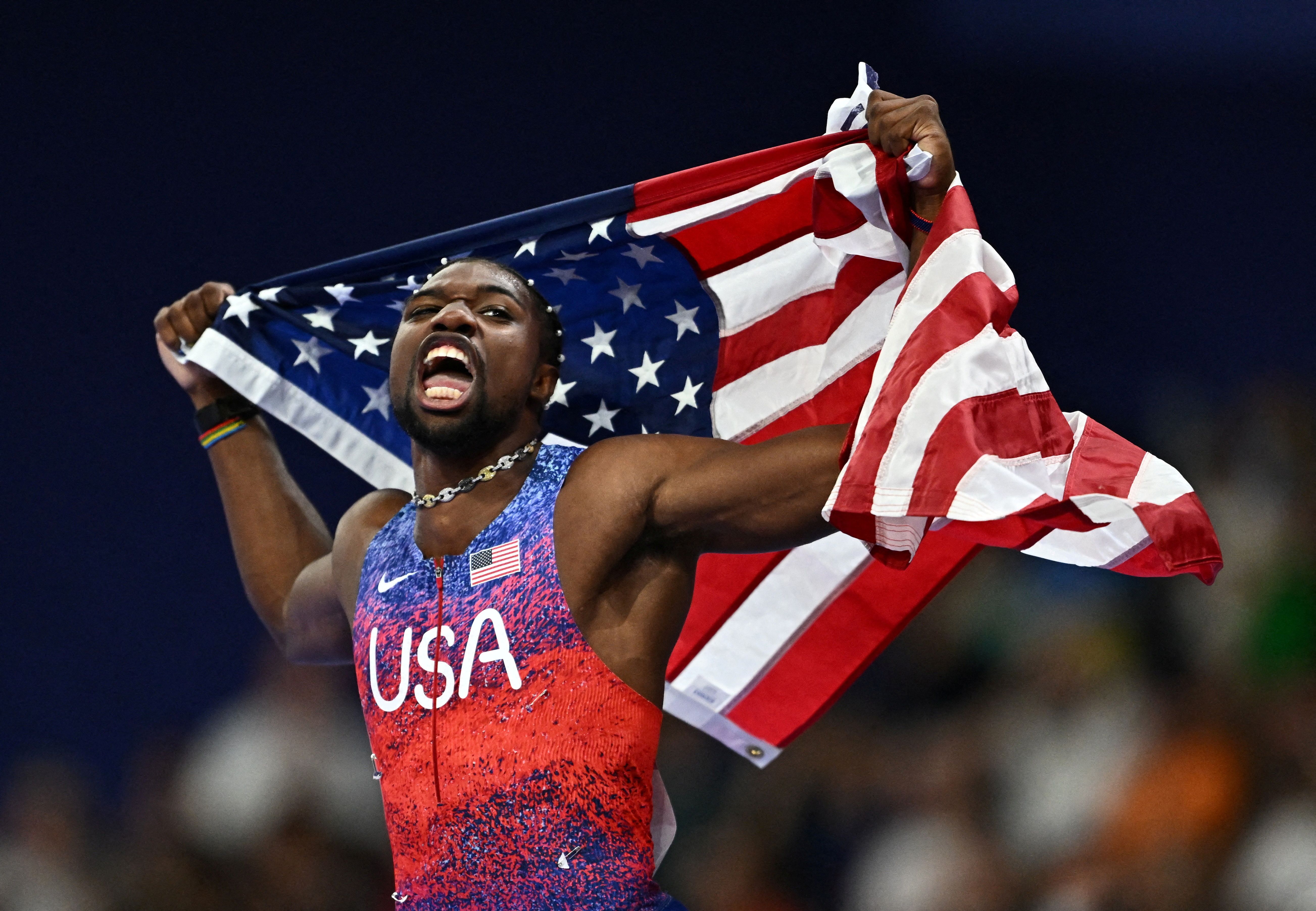 Noah Lyles celebrates after winning gold.