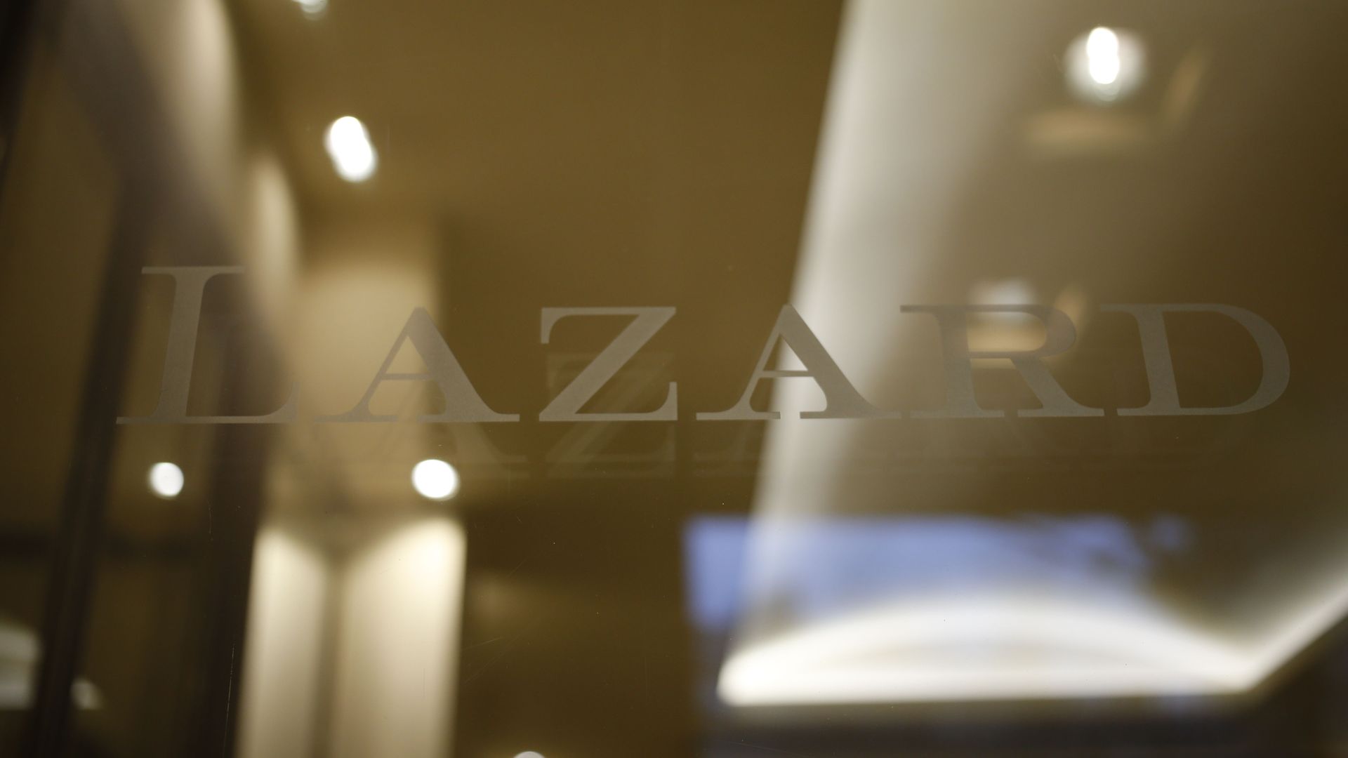 The logo of Lazard on a glass door.