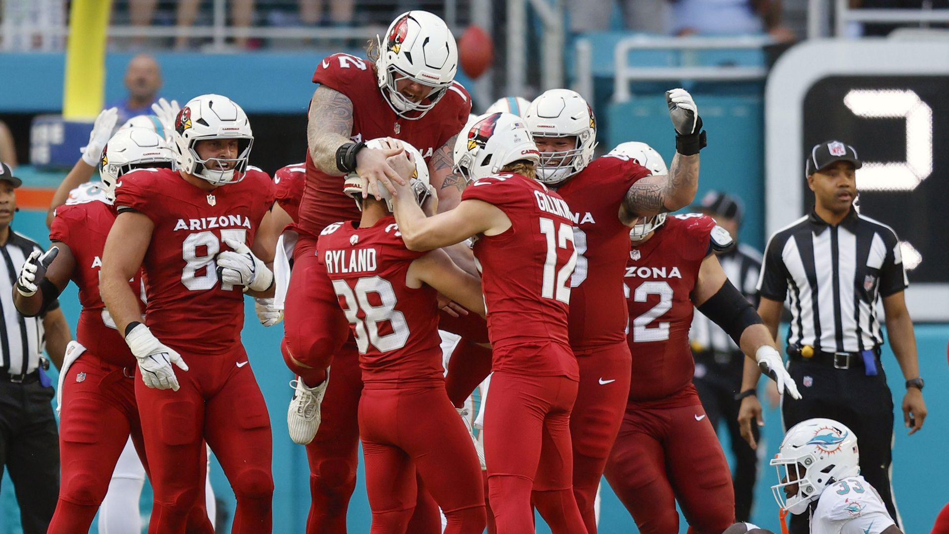 Arizona Cardinals players celebrate on the field. 