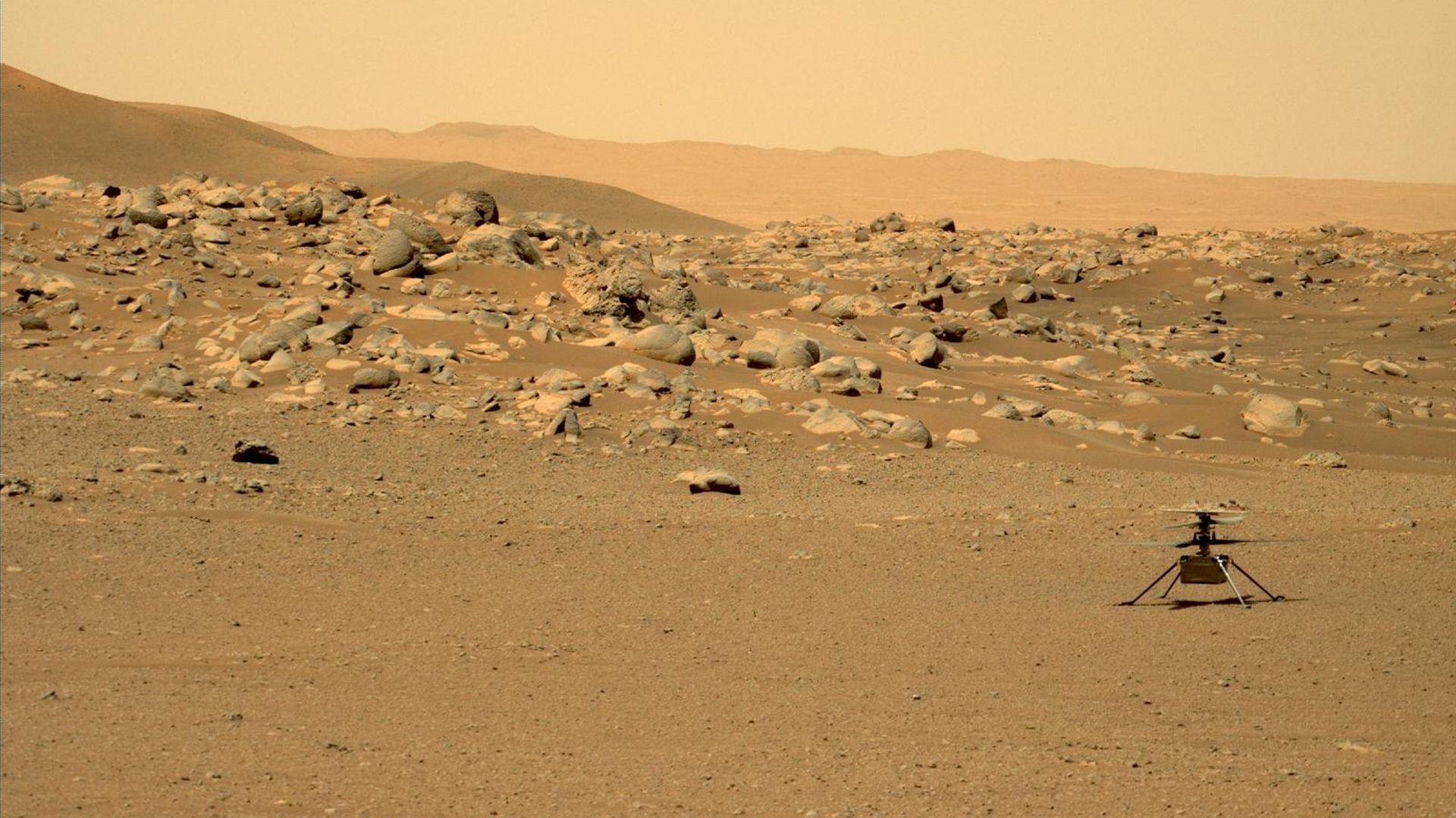 Ingenuity on the surface of Mars with boulders in the background