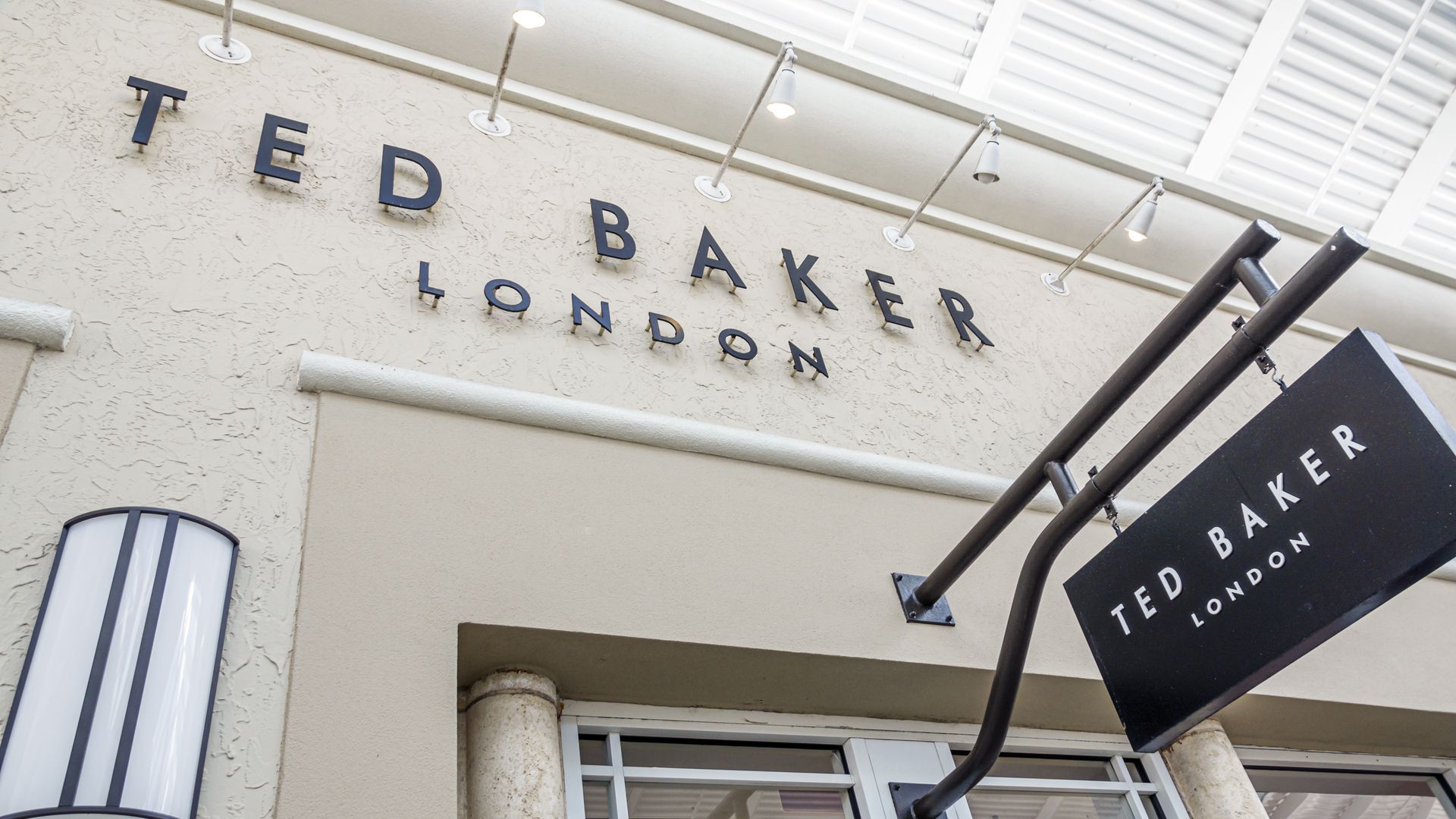 The Ted Baker banner is spelled out above a store entrance in black lettering.