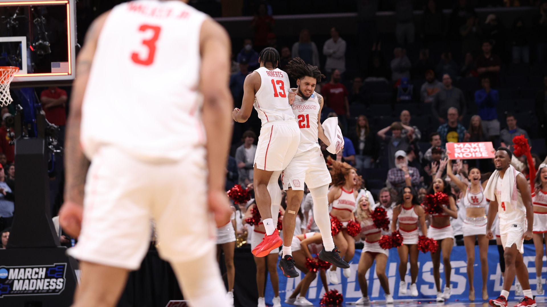 Two Houston Cougars men's basketball team players jump in celebration during a game
