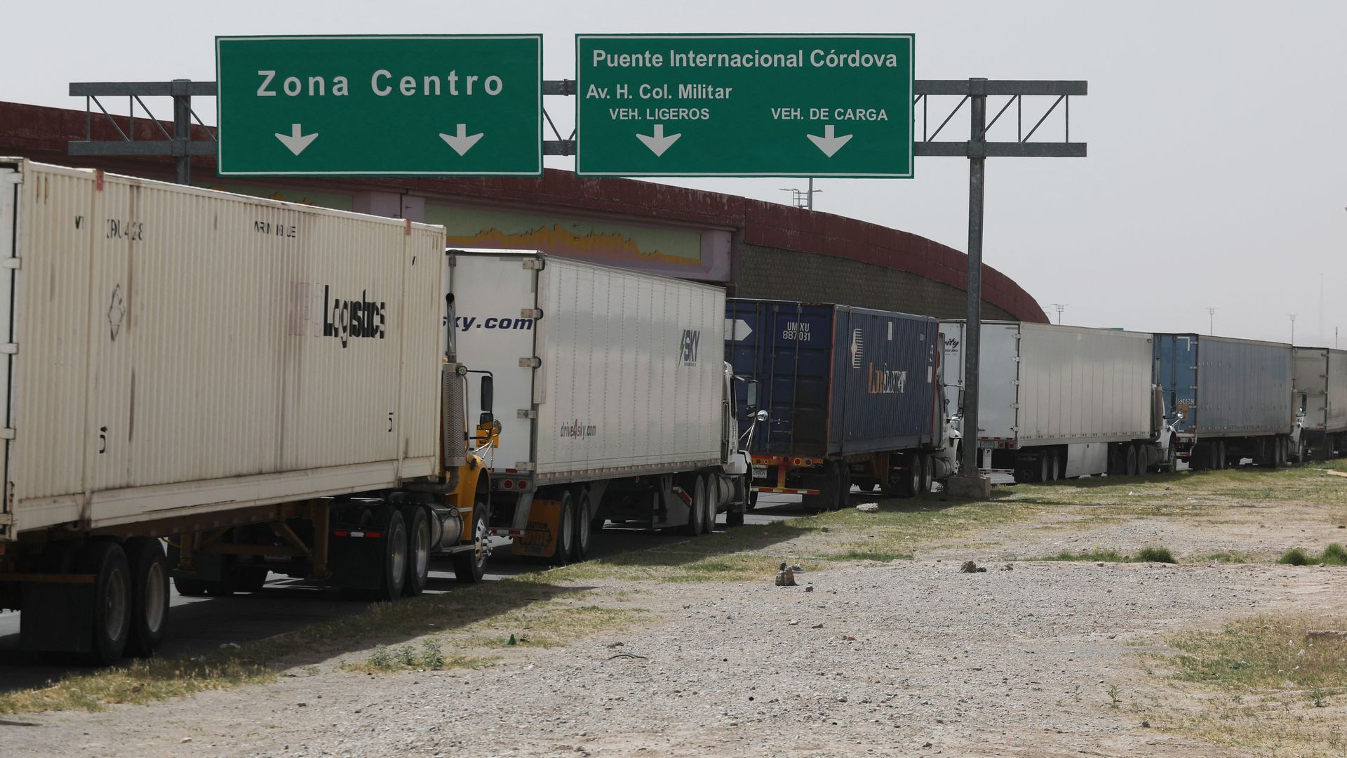 Large commercial semi-trucks are lined up in Mexico waiting to cross into the U.S. 