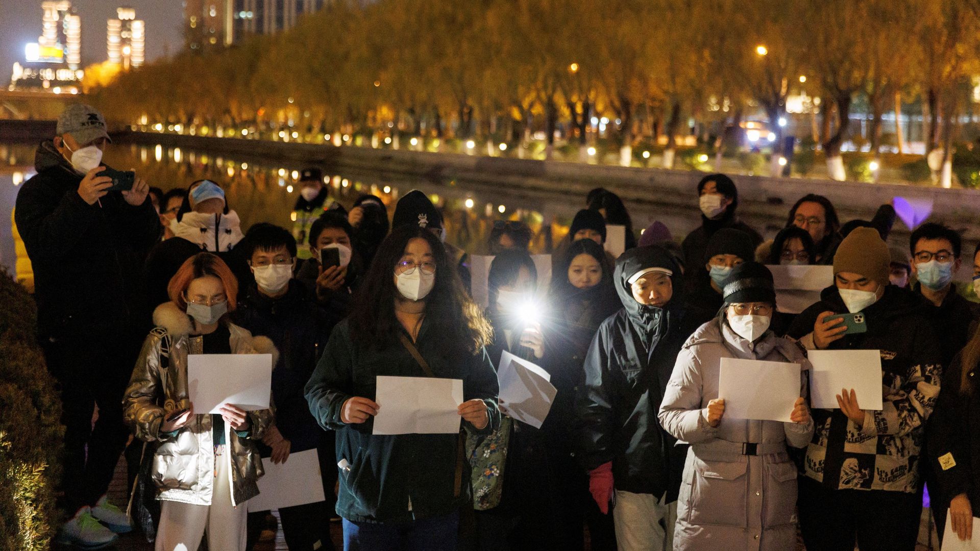 People hold white sheets of paper in Beijing yesterday to protest COVID restrictions.