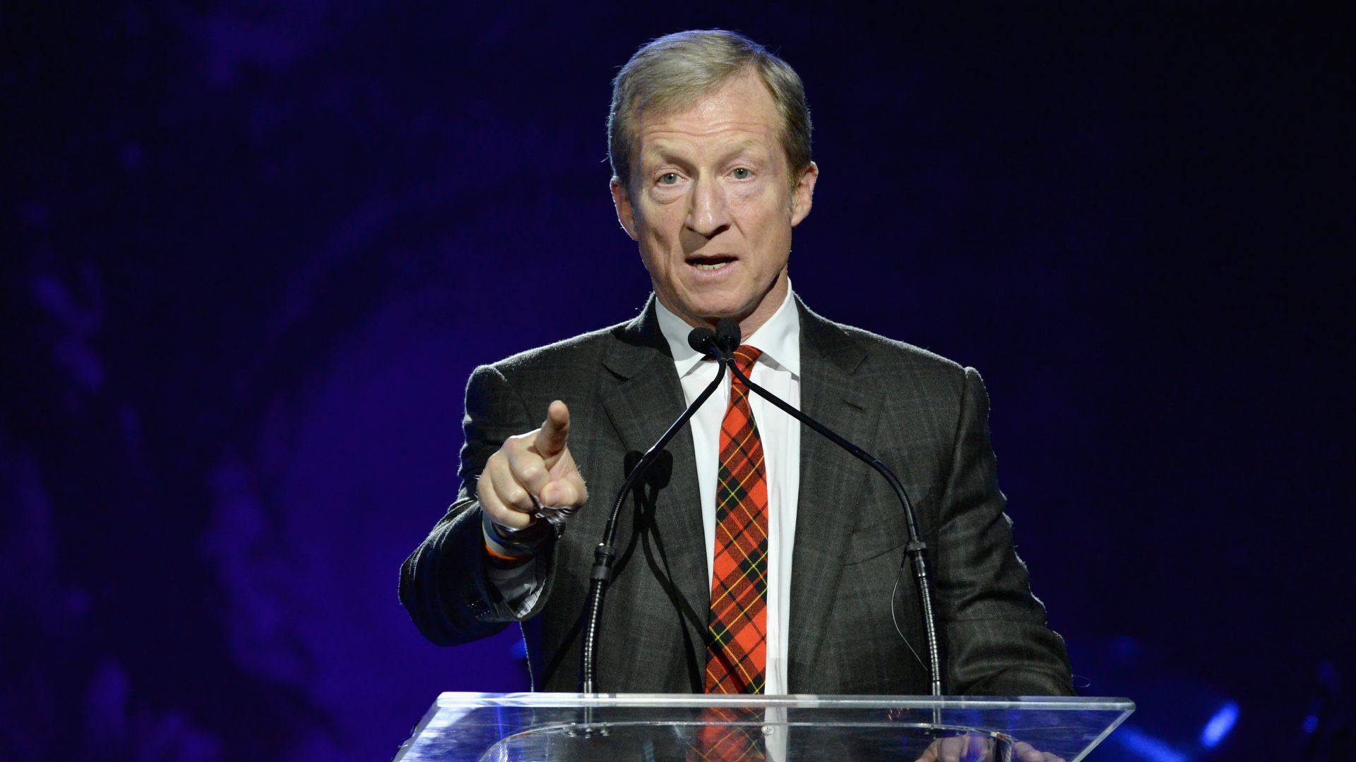 Tom Steyer points on stage while speaking to an audience