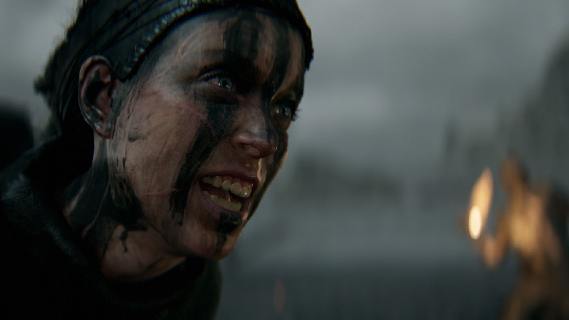 Screenshot of a person's face streaked with soot in a gameplay trailer