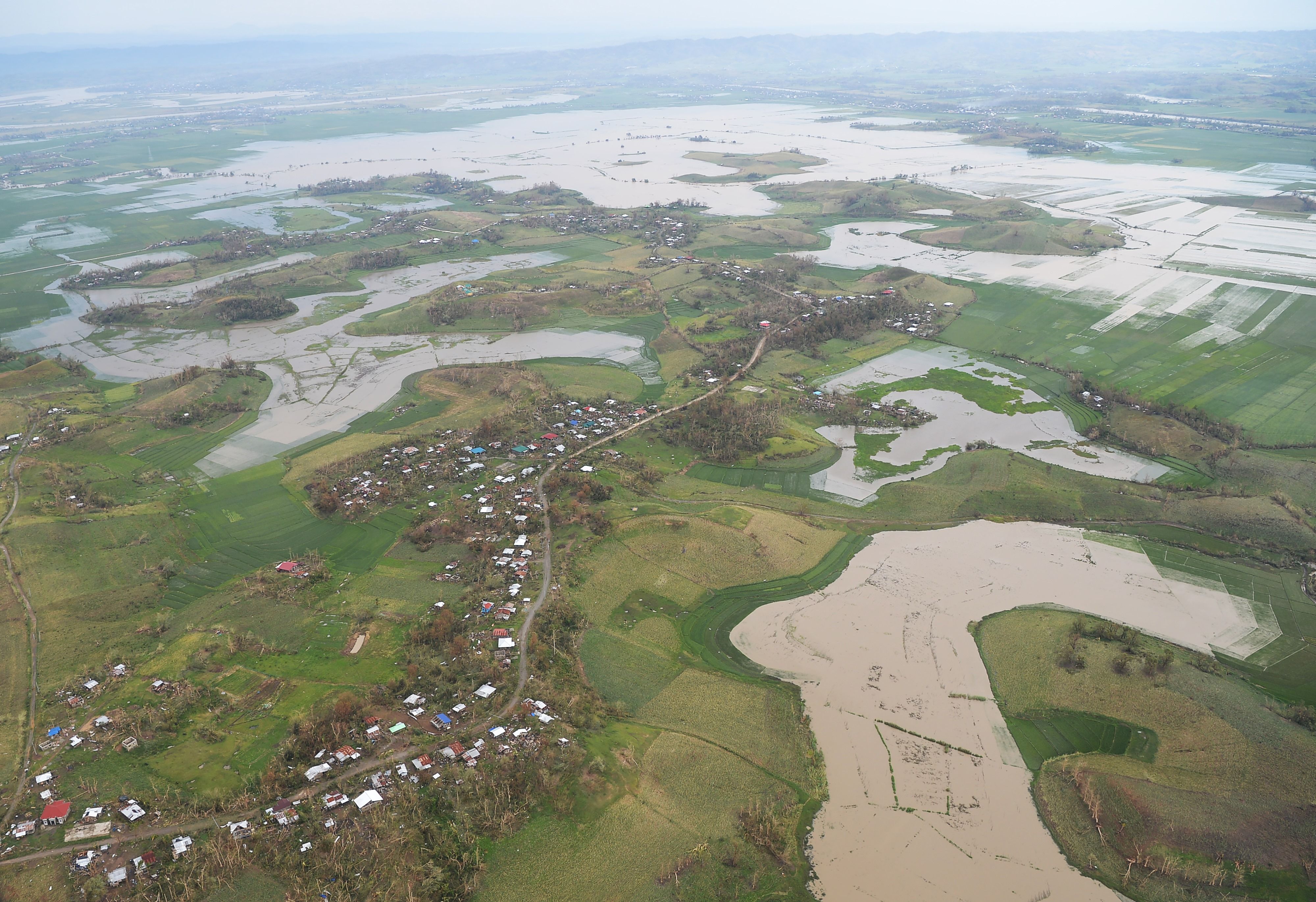 An aerial photo shows devastated homes and rice and corn fields inundated by floods.