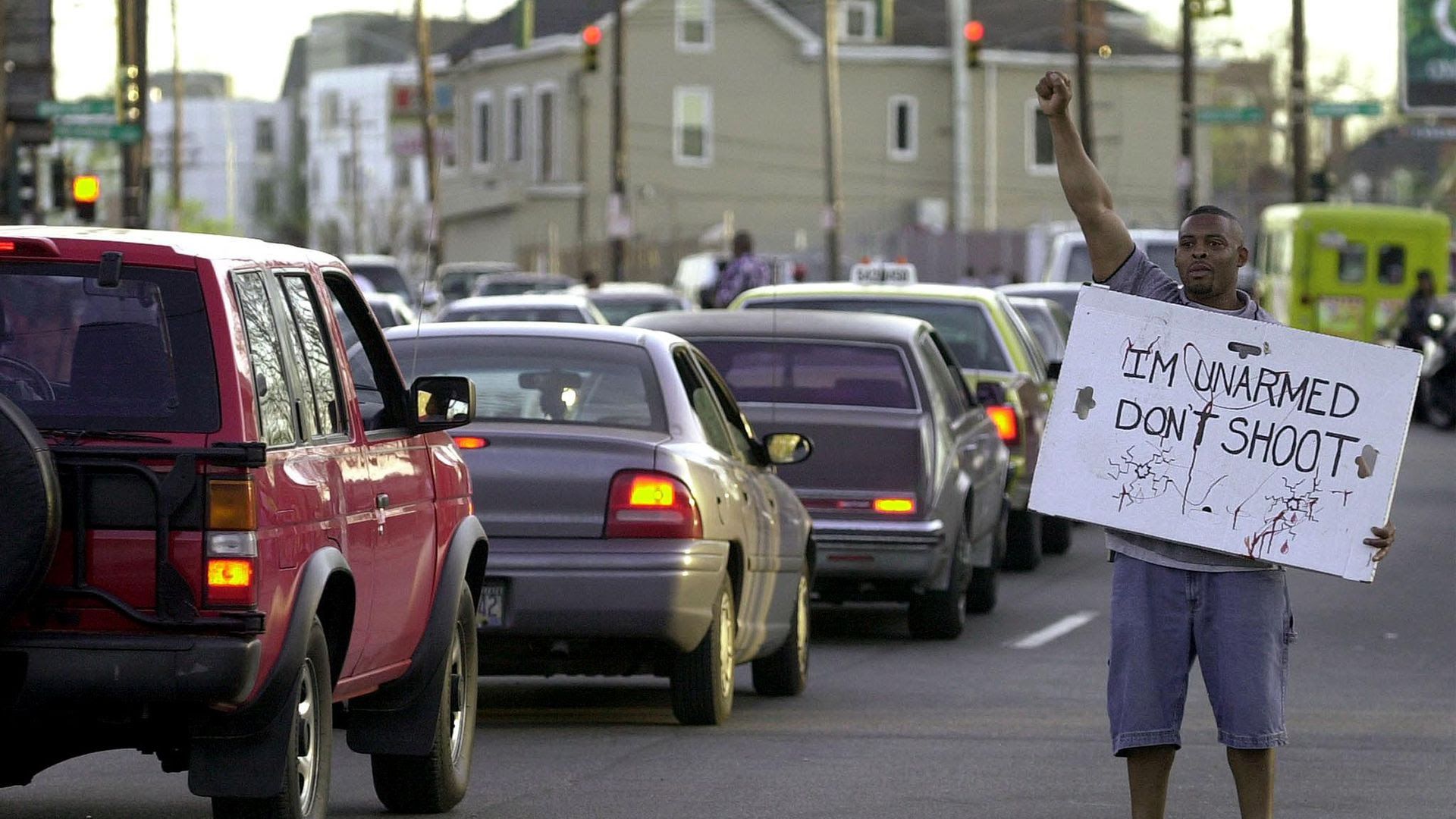Dion Jackson protests against police violence in downtown Cincinnati while holding a sign that says "I'm unarmed. Don't shoot."