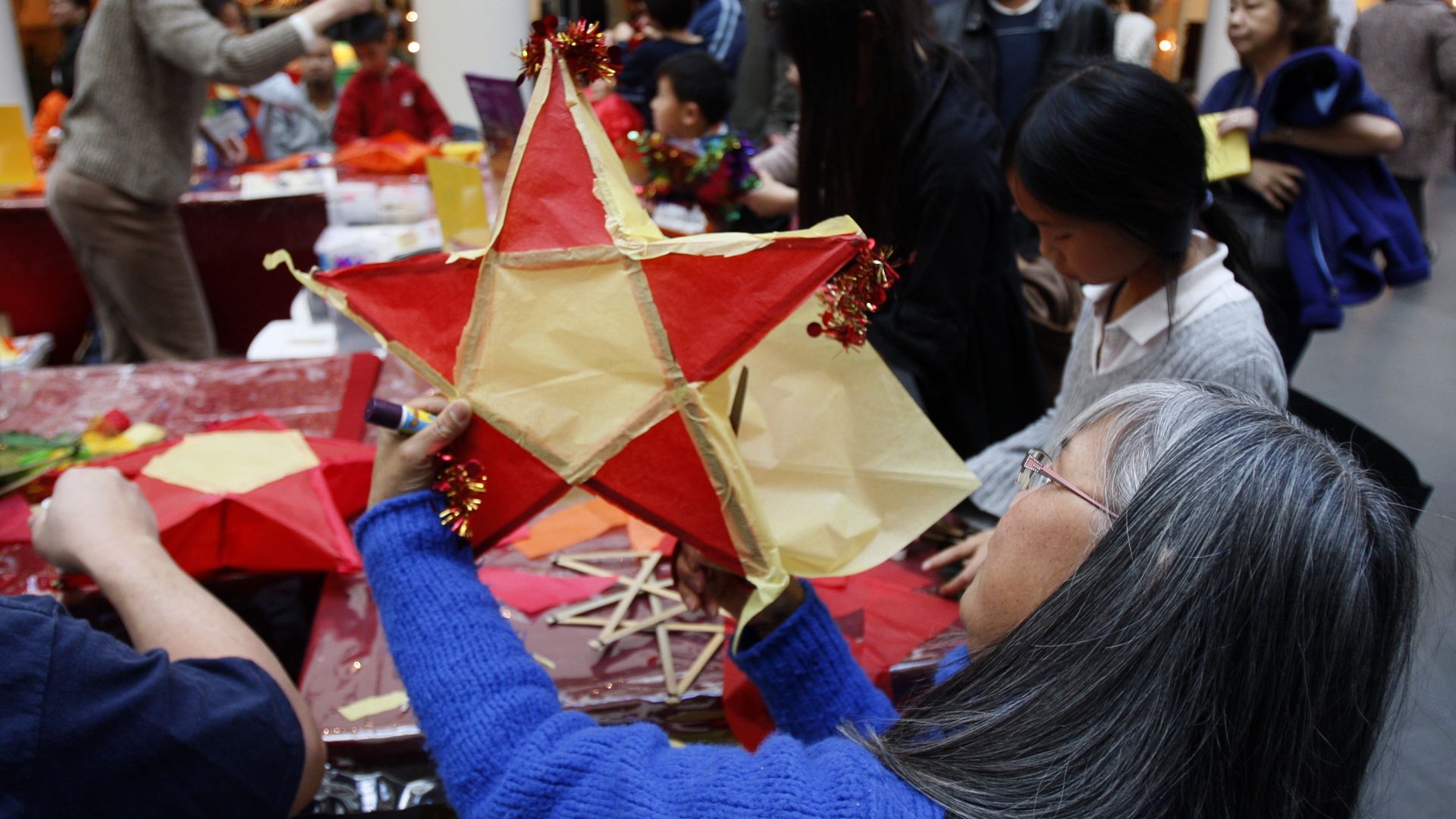 Photo of people making Filipino Christmas lanterns at a table