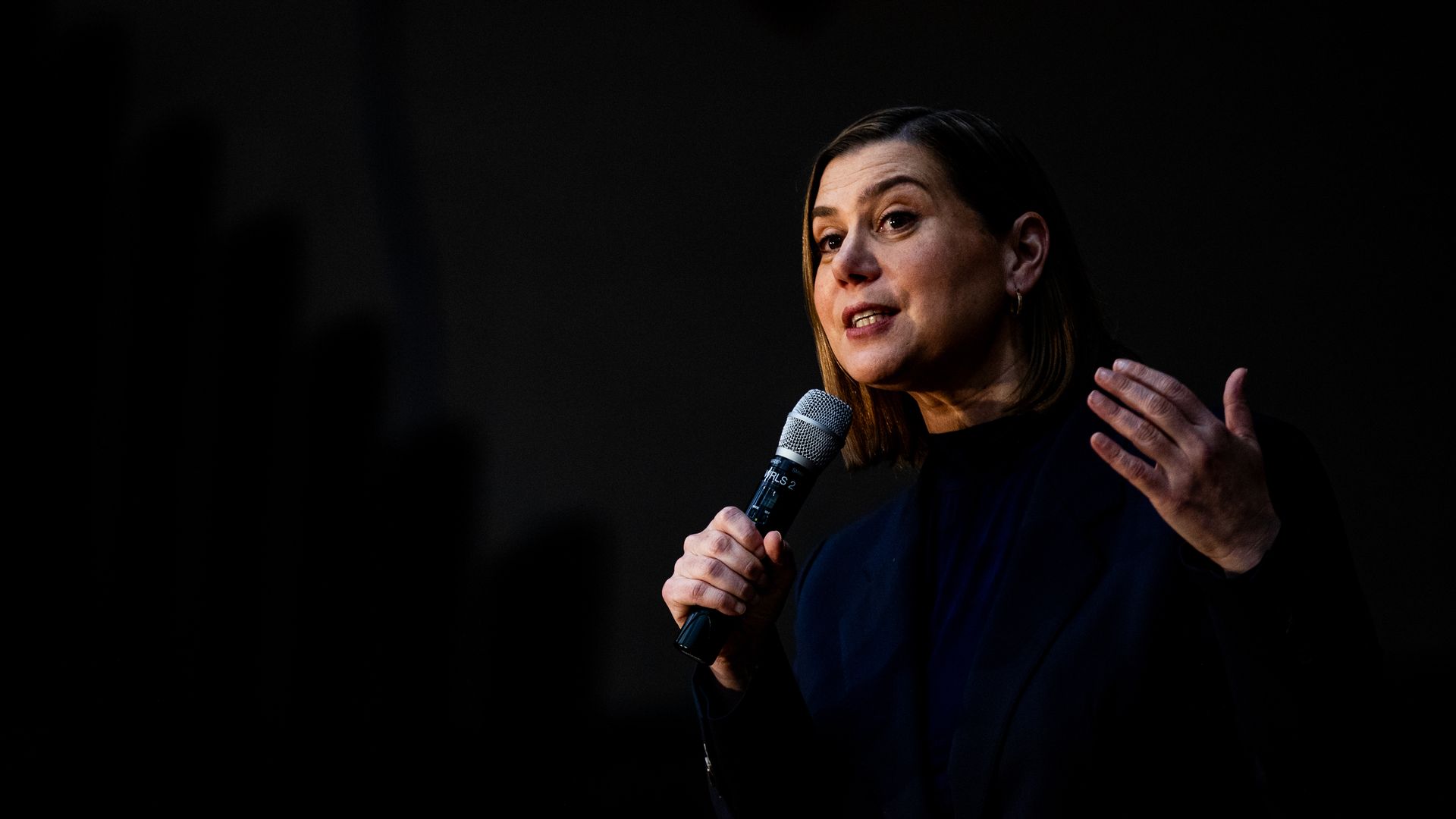 Sen. Elissa Slotkin, wearing a blue suit and speaking into a microphone in front of a black backdrop.