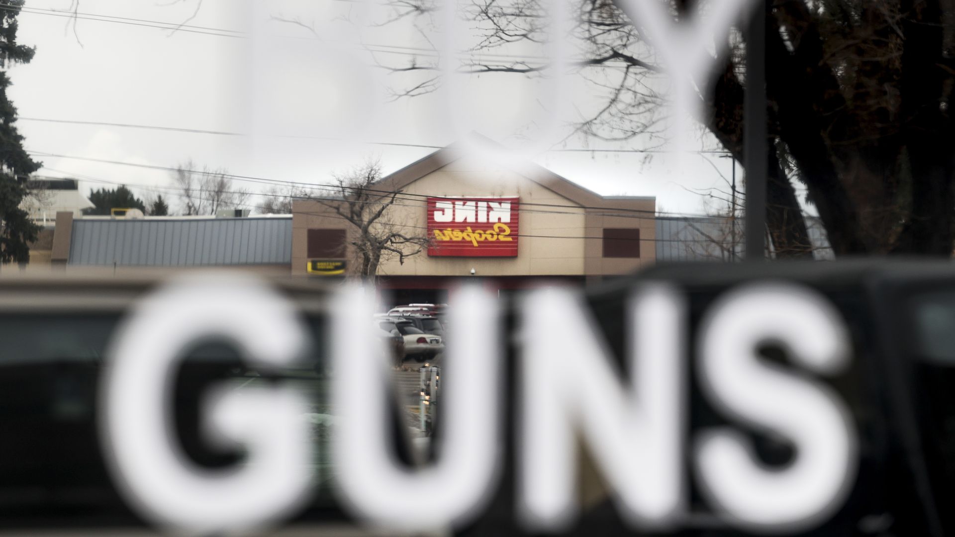 A King Soopers grocery store, not connected to the Boulder shooting, is reflected in the window of the Eagles Nest Armory in Arvada.